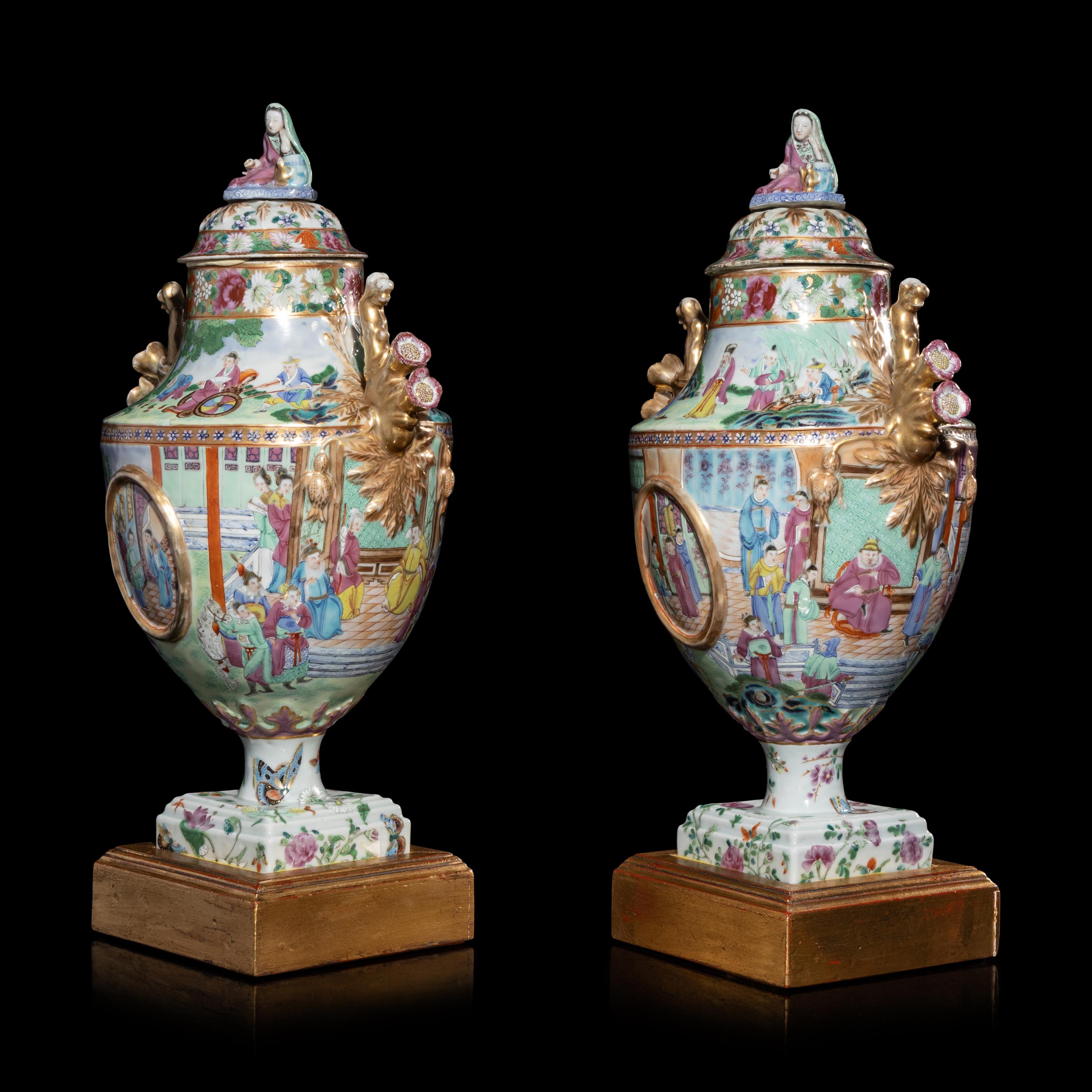 A Pair of Chinese Export Canton Famille Rose Porcelain Covered Urns, Early 19th Century — 清晚期 外銷廣彩人物故事圖獎杯形賞瓶一對
