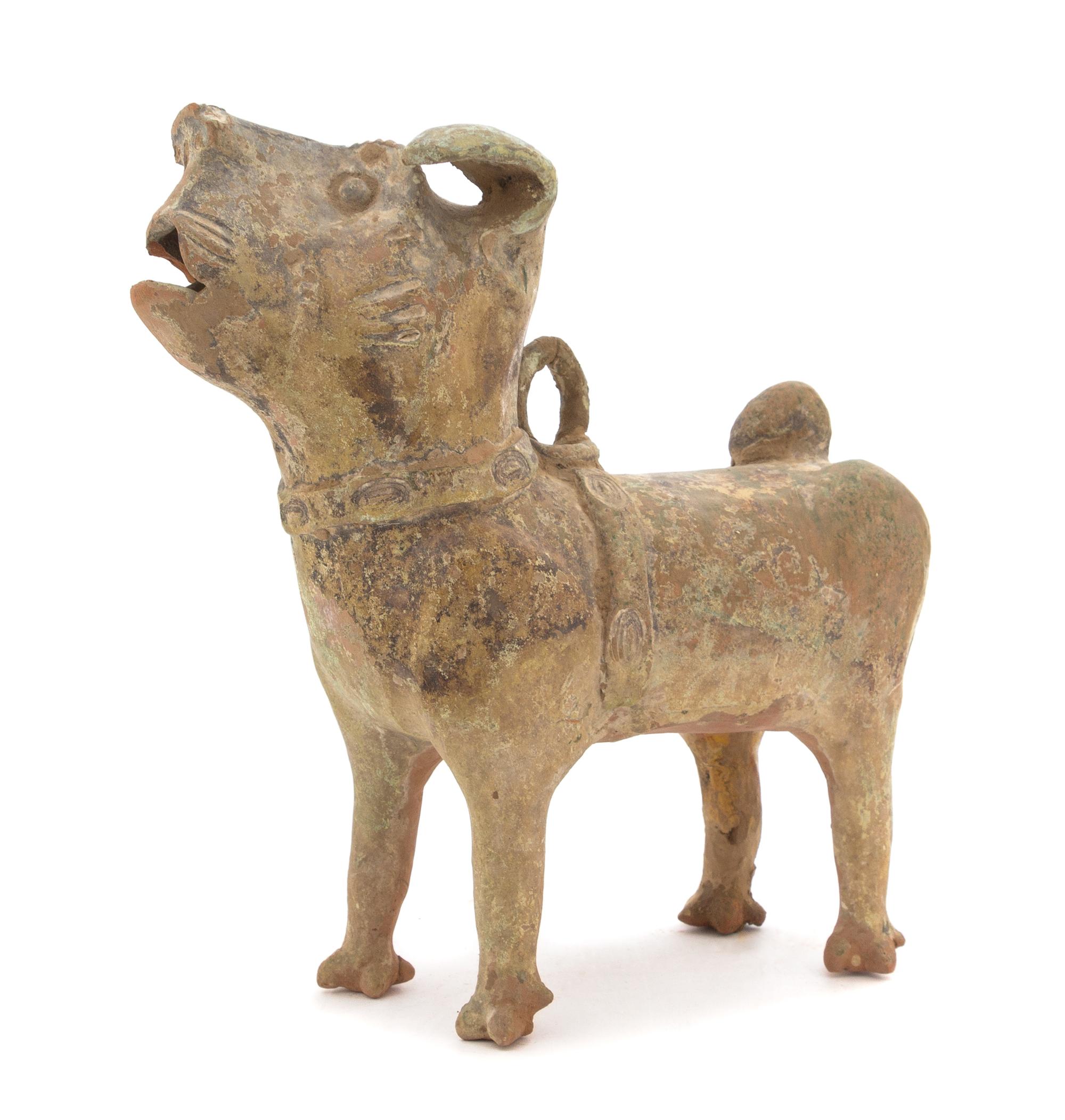 A Chinese Green Glazed Pottery Figure of a Dog Height 13 1/4 inches. — HAN DYNASTY (206 B.C. - A.D. 220)