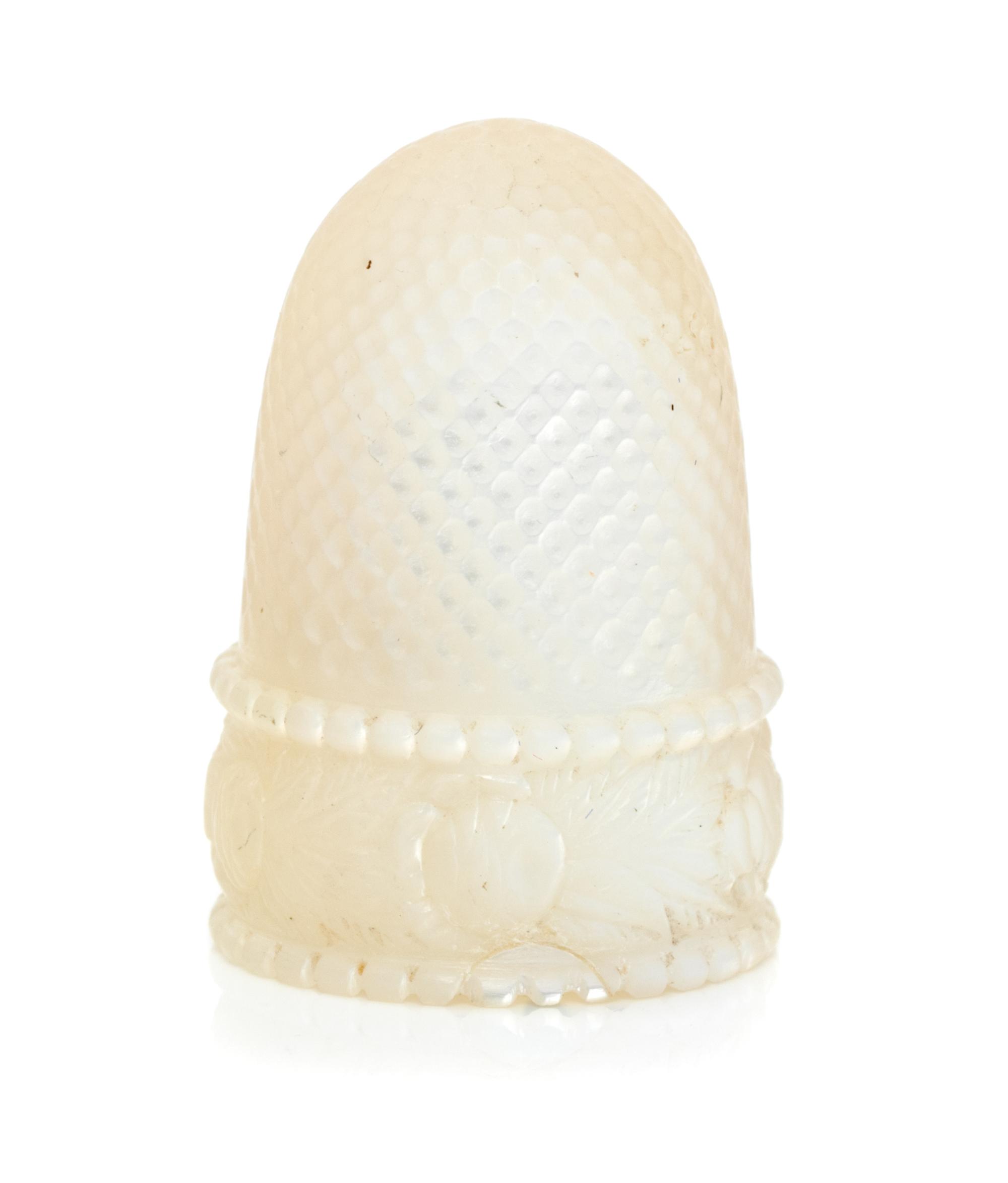 A French Palais Royal Mother-of-Pearl Thimble, 19th Century, the domed body above the band carved to show floral and foliate decoration