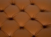 A Regency Style Brown Tufted Leather Upholstered Ottoman