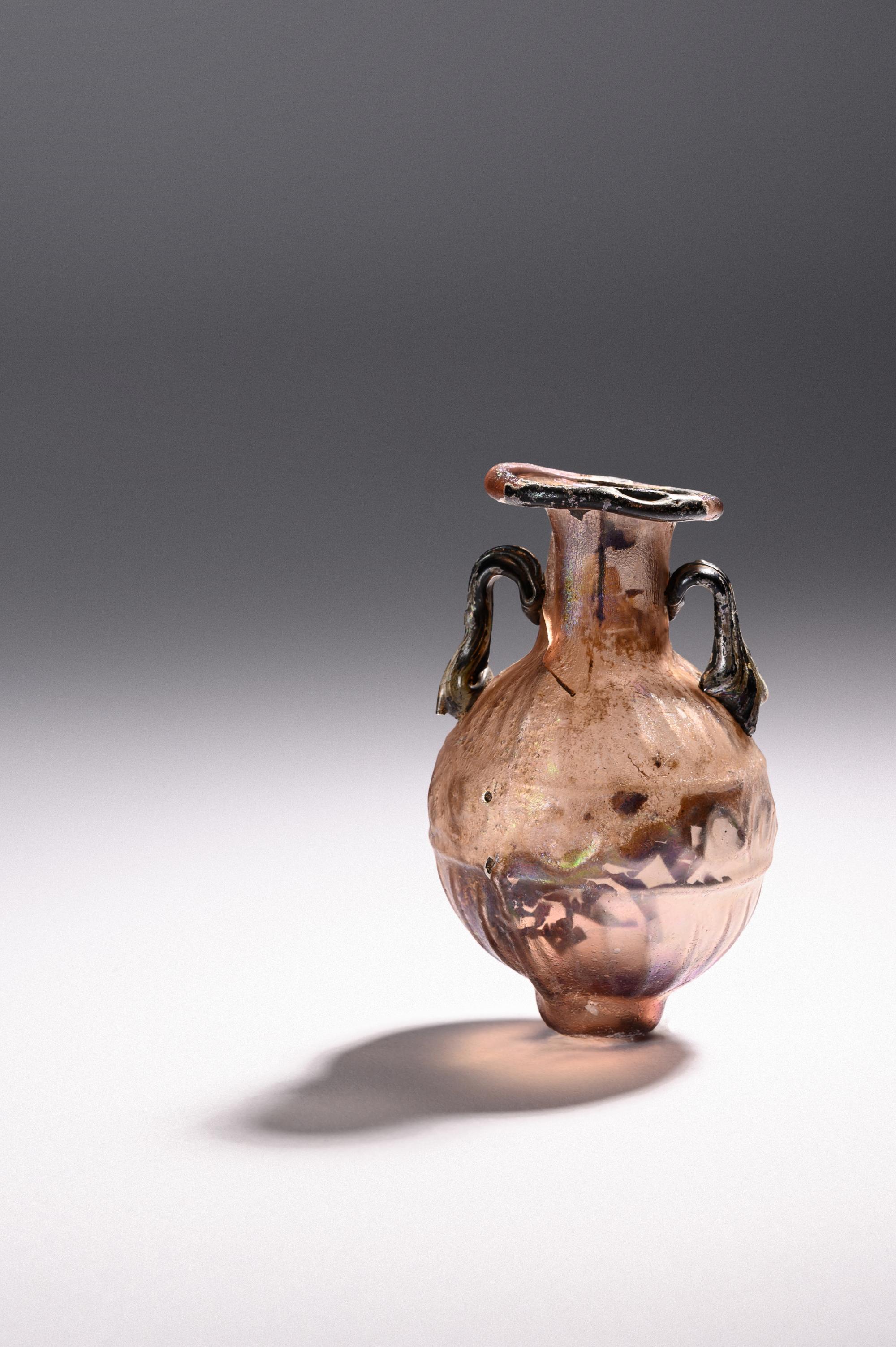 A Sidonian Mold-Blown Aubergine Glass Flask with Tendril Scrolls