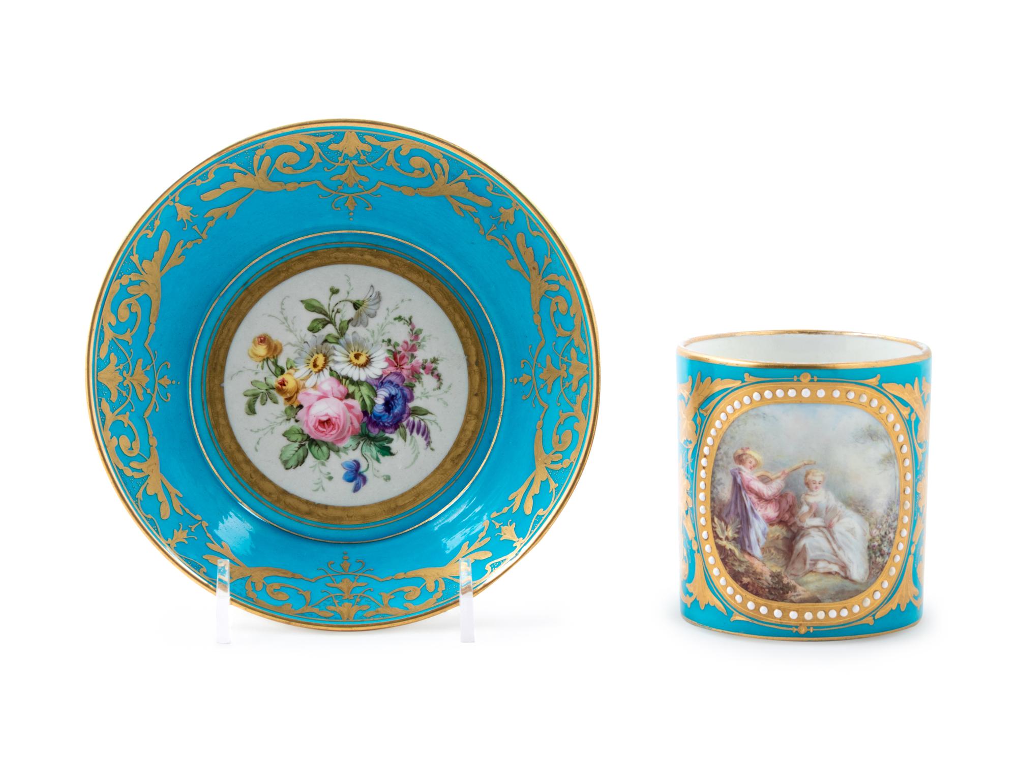 A Sèvres Style Painted, Parcel Gilt and "Jeweled" Turquoise-Ground Porcelain Cup and Saucer