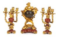 A French Gilt Bronze and Rouge Marble Clock Garniture Height of mantel clock 19 inches; height of candelabra 15 inches. — 19TH CENTURY