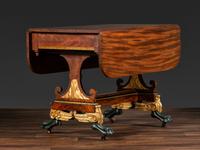 A Classical Parcel Gilt and Ebonized, Figured Mahogany Paw-Foot Drop-Leaf Table
