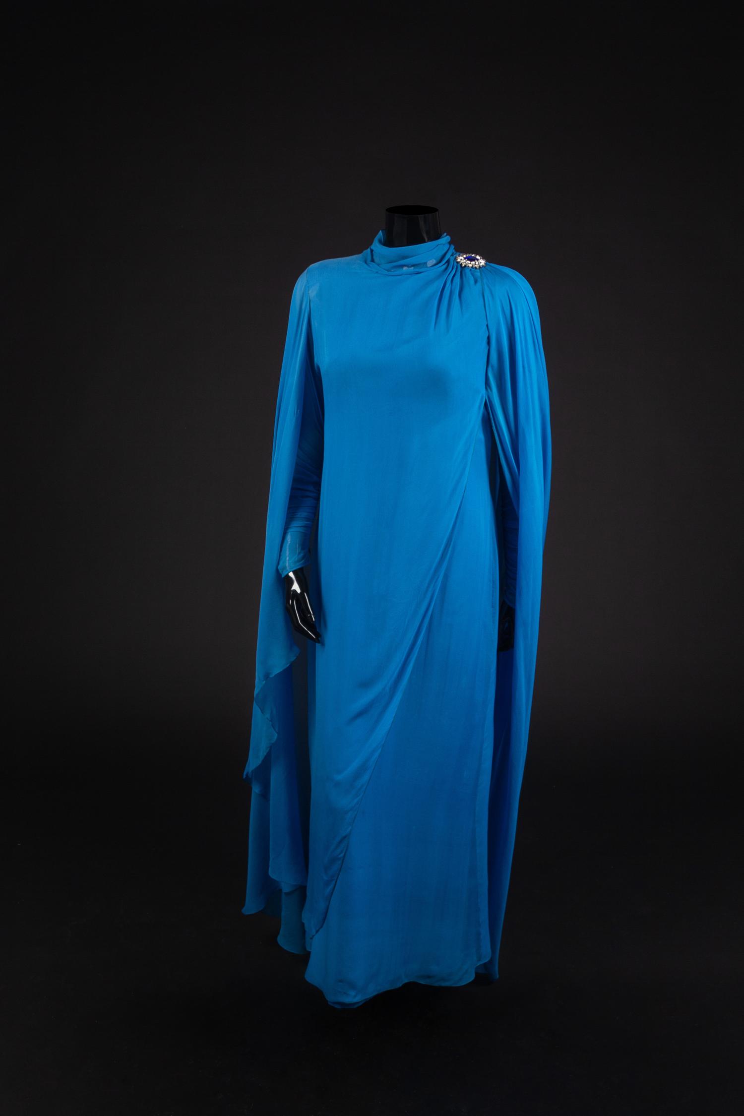 Dress and Shoes, 1982. Dress design by Paul Zastupnevitch, made by Western Costume Company in Los Angeles. — Worn by Olivia de Havilland for ‘The Night of a Hundred Stars II” at the Radio City Hall in New York in 1985. Also worn for the White House State Dinner given by Ronald Reagan in honor of President Francois Mitterand on March 22, 1984.