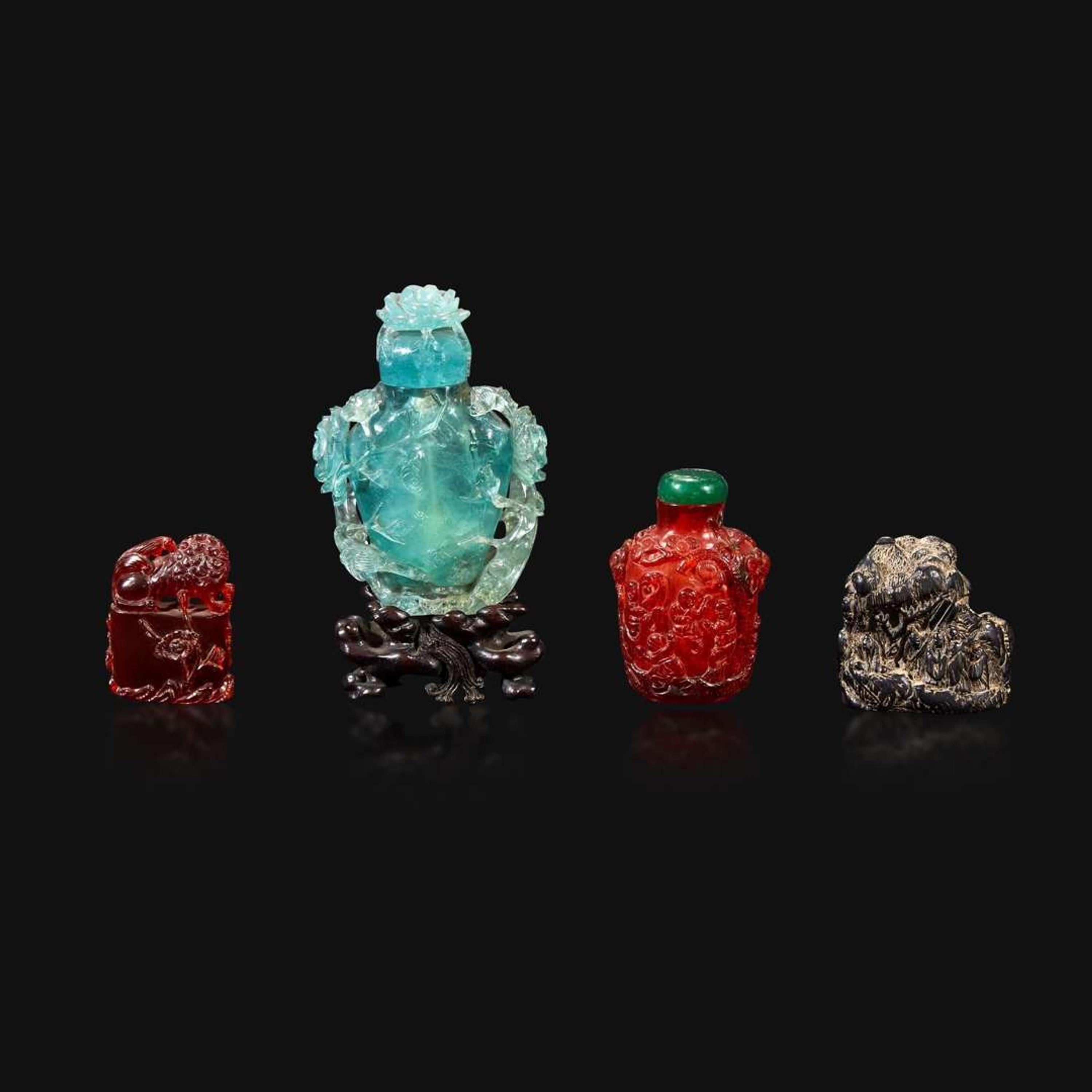 A Chinese carved aquamarine snuff bottle, an amber lion-form seal, and an amber snuff bottle Qing Dynasty