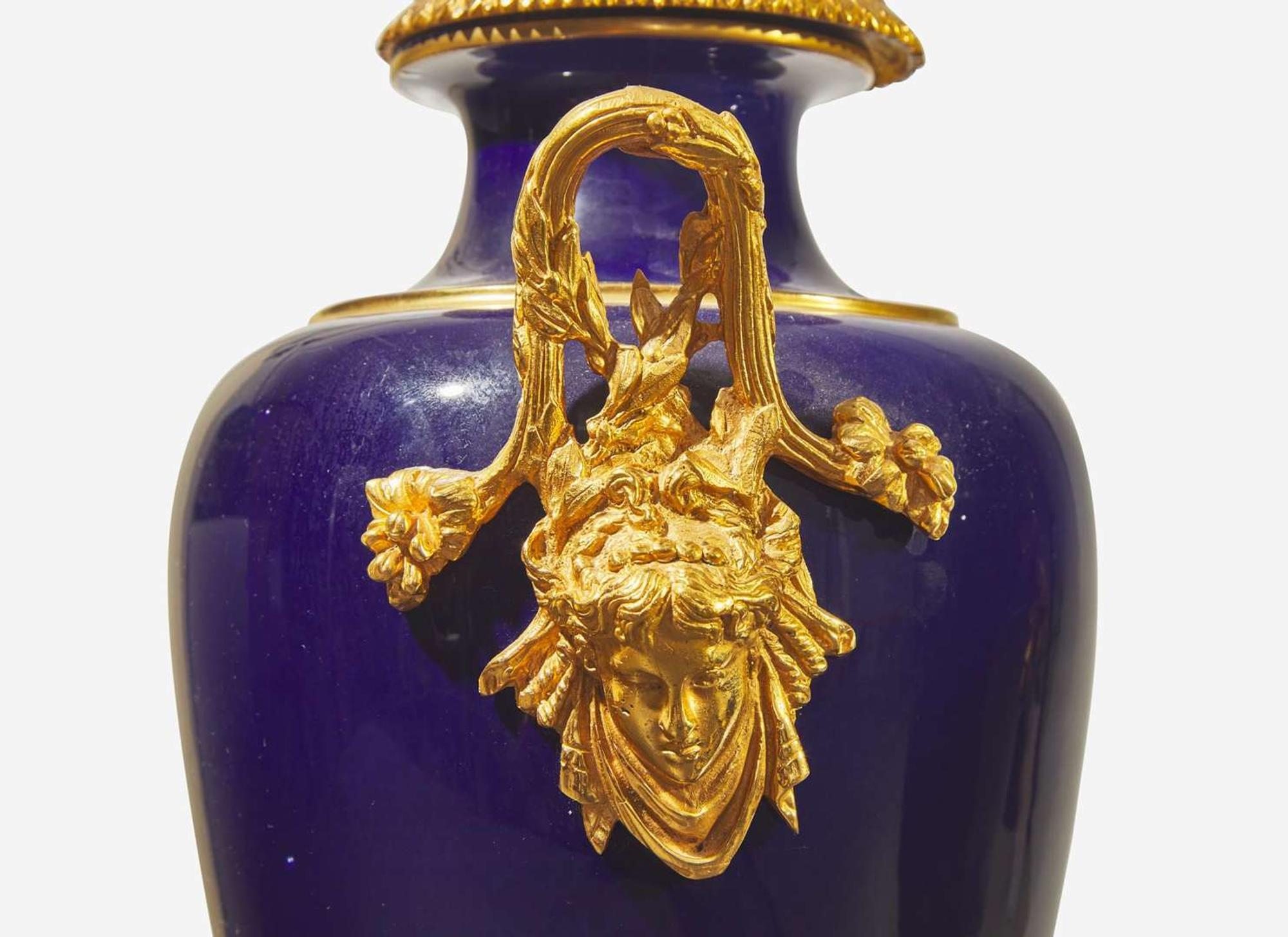 A pair of French gilt bronze mounted cobalt blue porcelain urns, late 19th / early 20th century