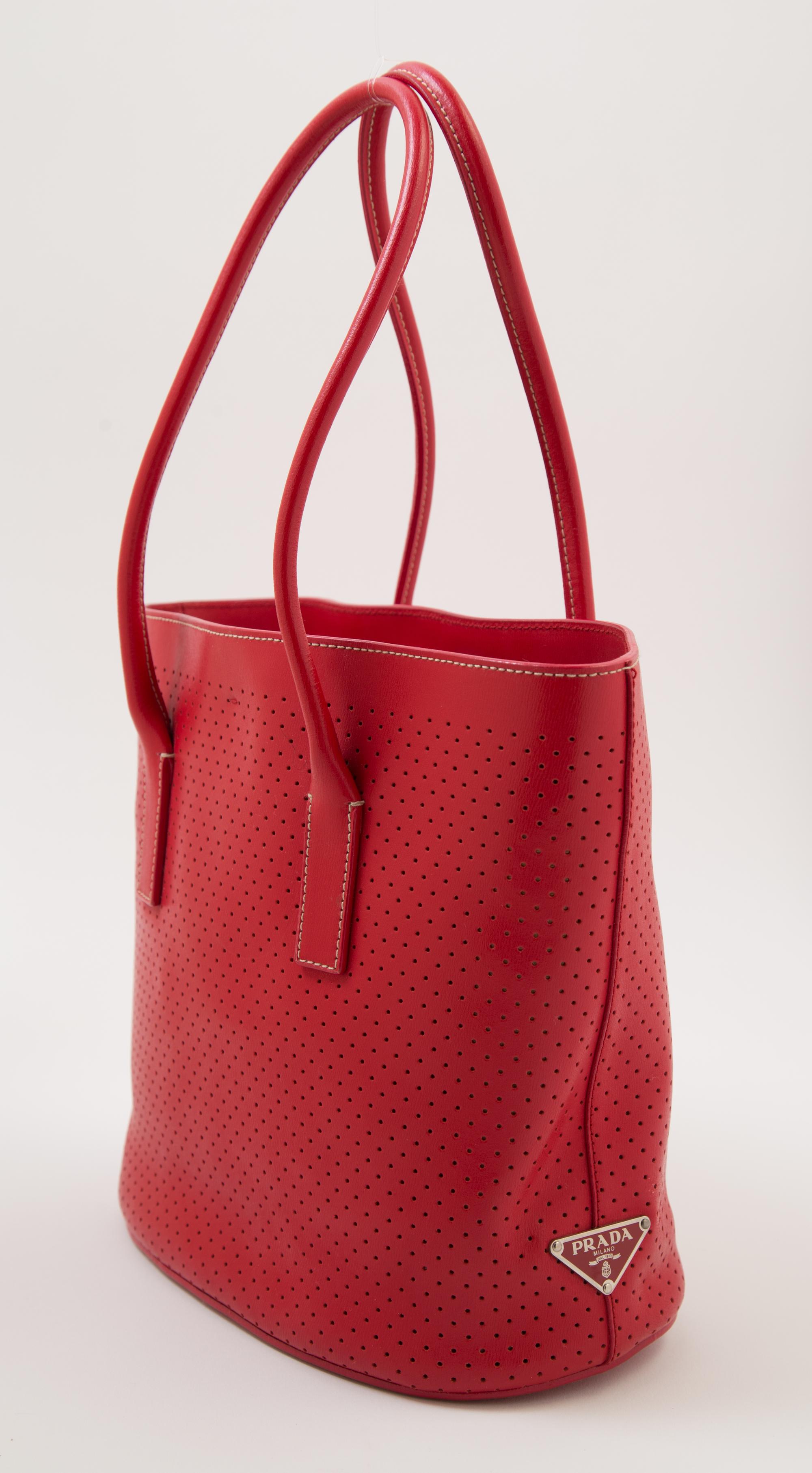 A Prada Red Leather Perforated Tote Bag, 11" x 9" x 3.5"; Handle drop: 7.5".