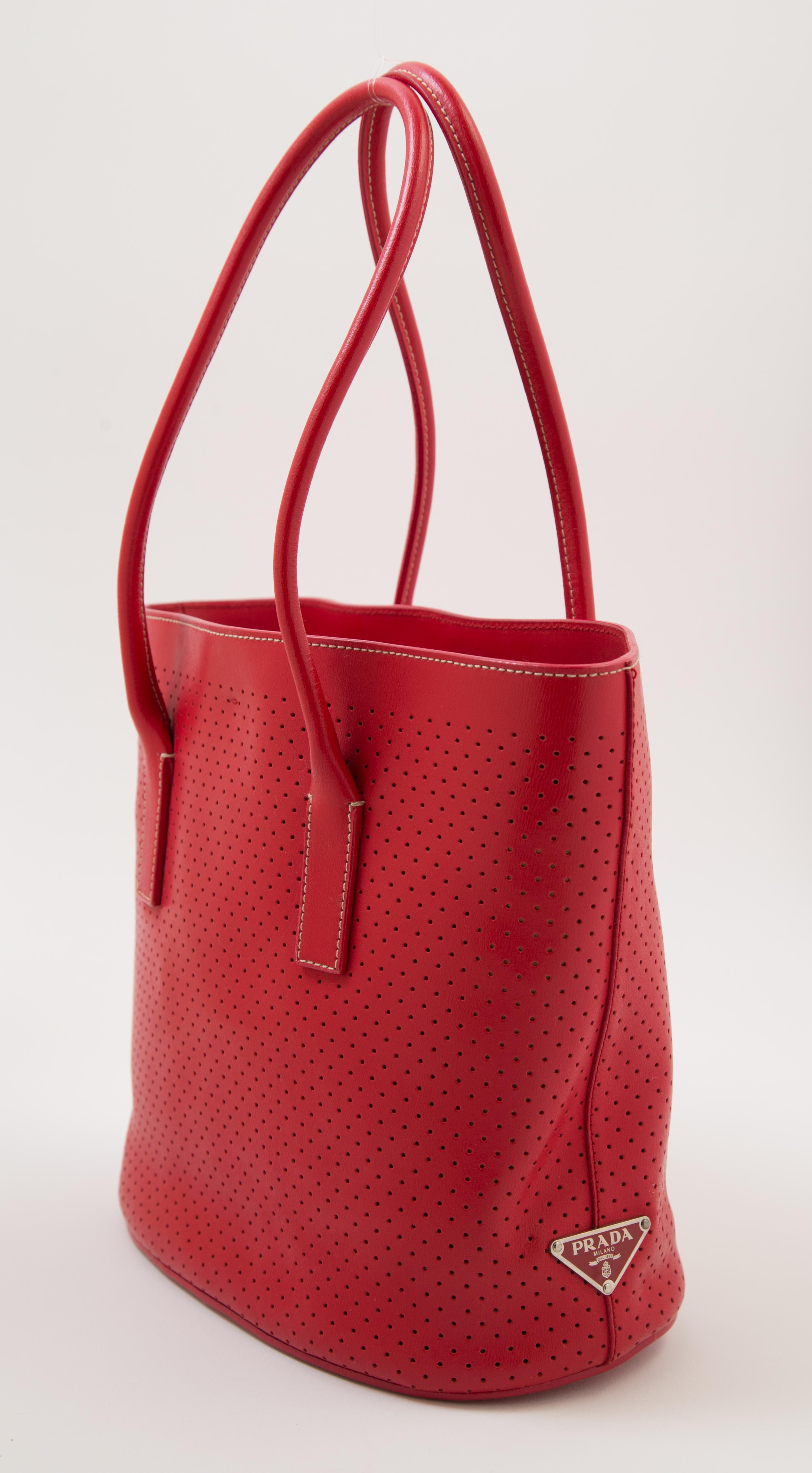 A Prada Red Leather Perforated Tote Bag, 11" x 9" x 3.5"; Handle drop: 7.5".