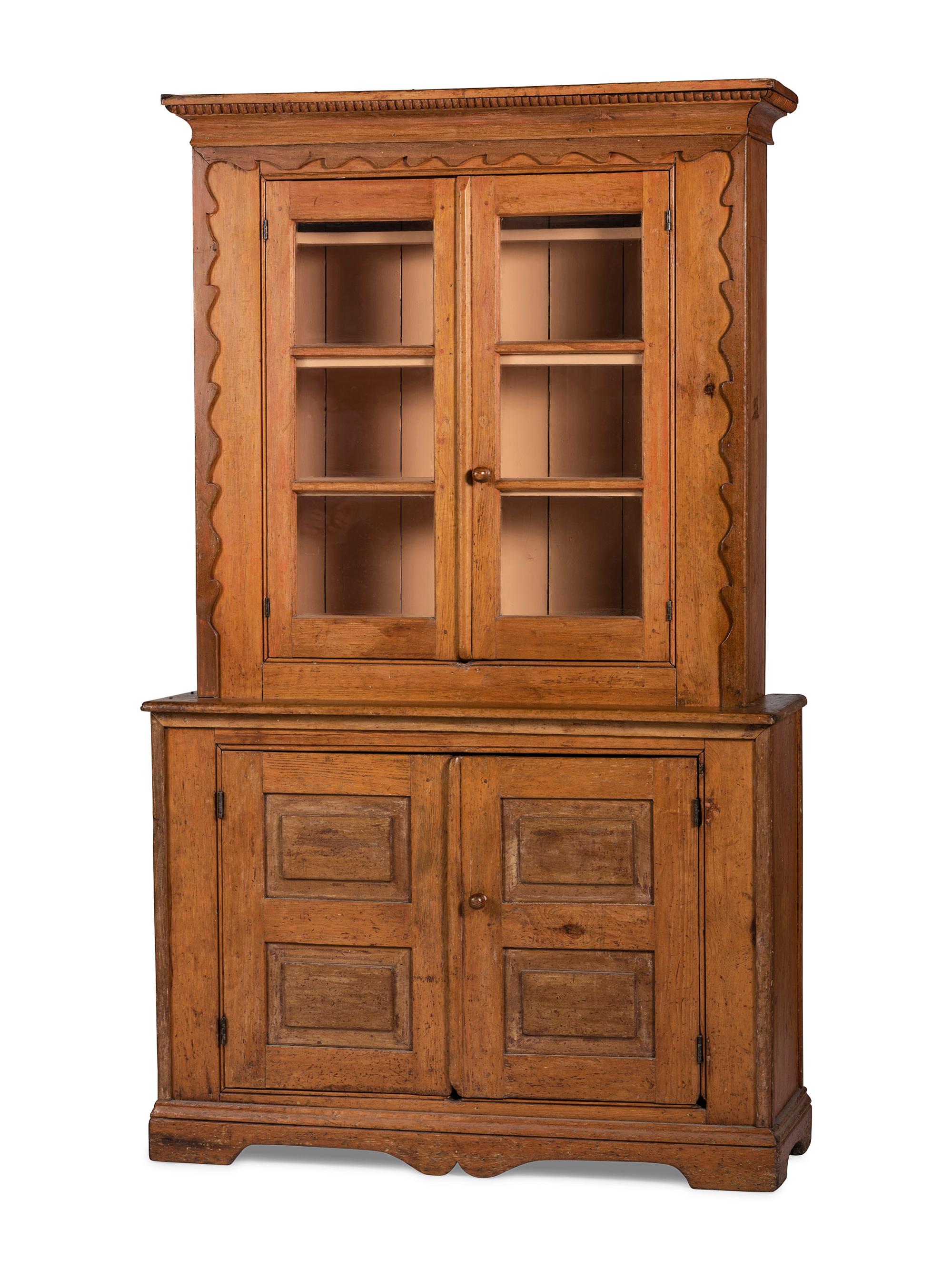 A Folk Art Carved and Paneled Pine Step-Back Cupboard