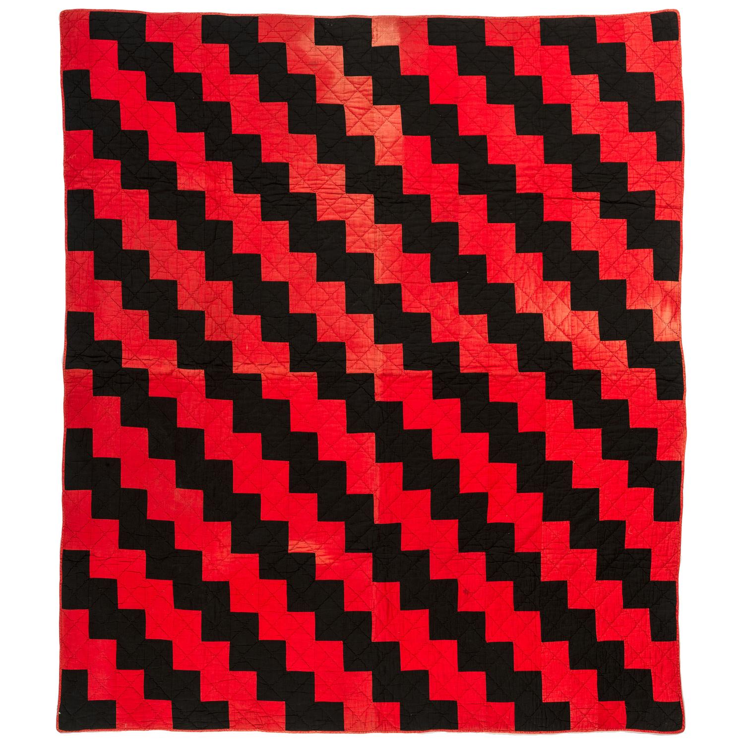 A Red and Black Pieced Zig Zag Pattern Quilt