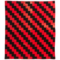 A Red and Black Pieced Zig Zag Pattern Quilt