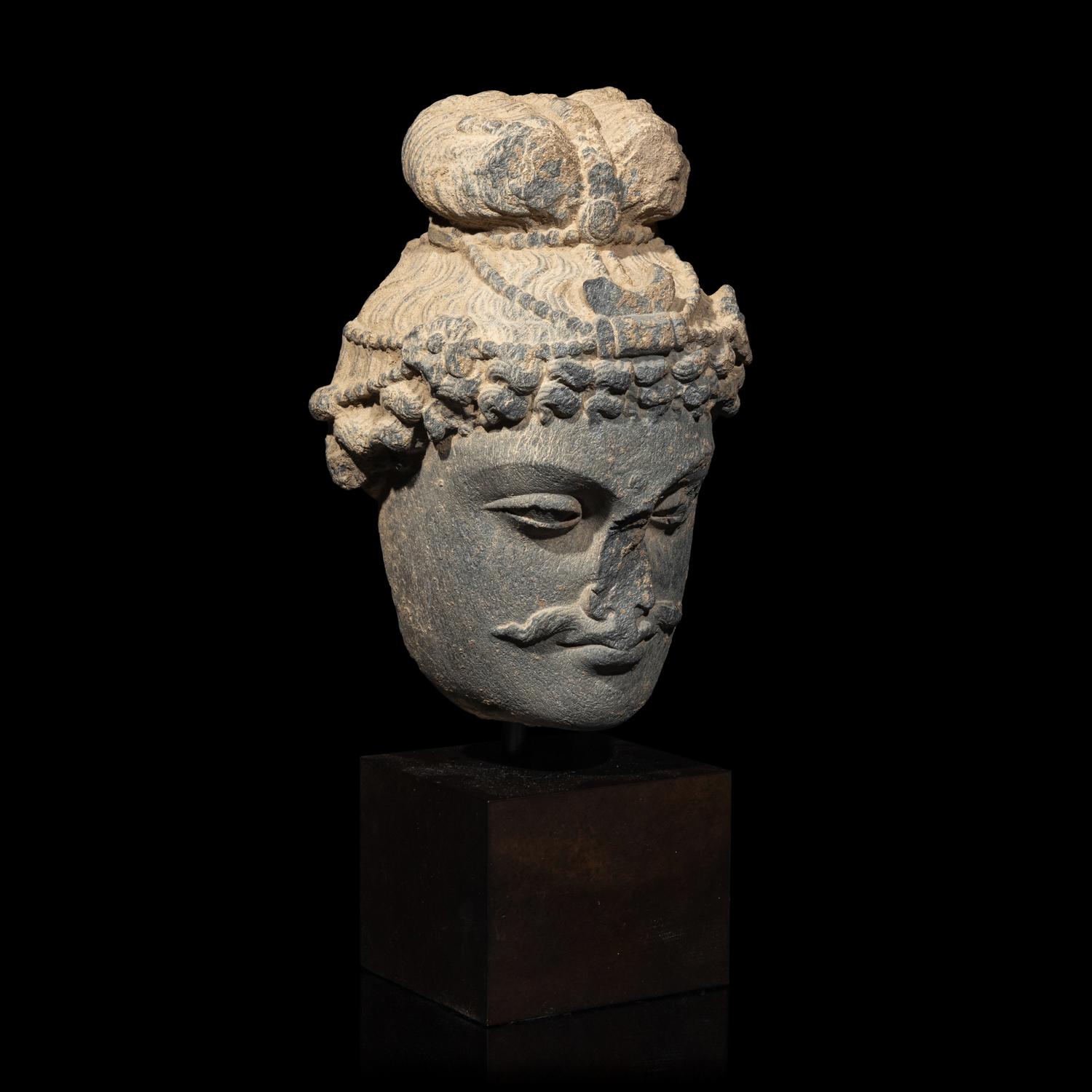 A Gandharan Grey Schist Head of a Bodhisattva, 2nd/3rd Century