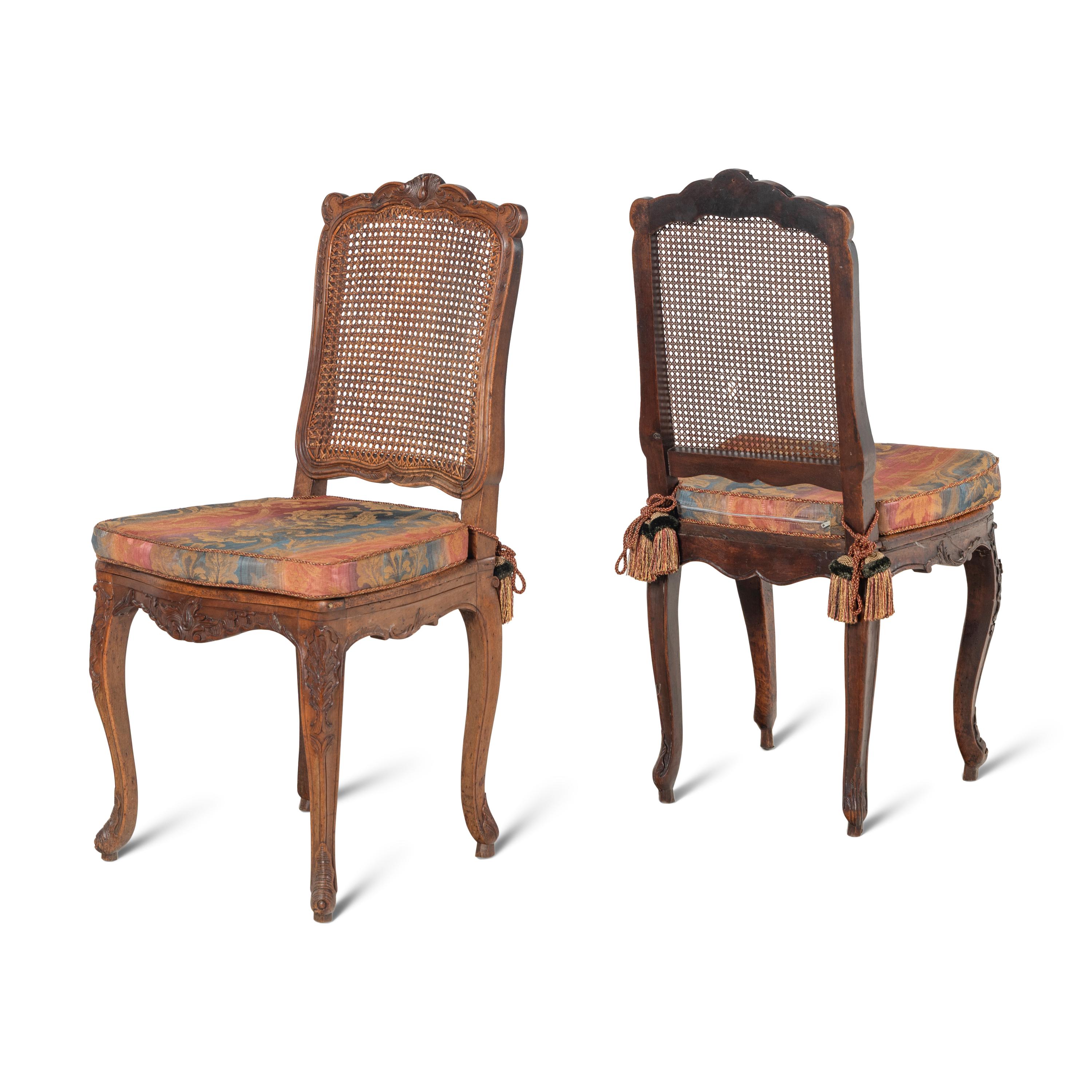 A Set of Eight French Carved Walnut and Caned Dining Chairs