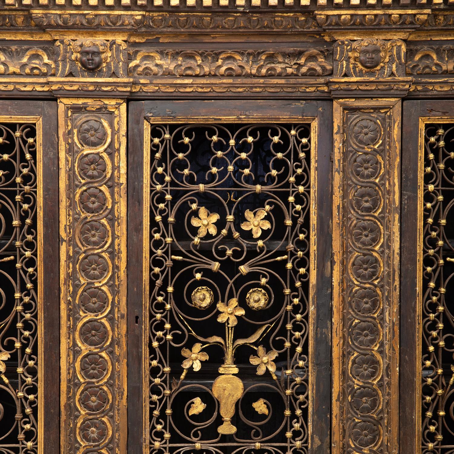 An Italian Iron-Mounted and Parcel Gilt Bookcase Supplied by Addison Mizner for the Everglades Club, Palm Beach