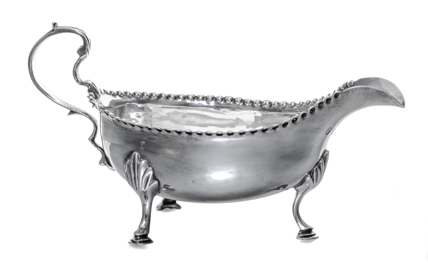 A George III Silver Sauce Boat, Hester Bateman, London, 1781, having a double scroll handle and a beaded edge, raised on foliate worked