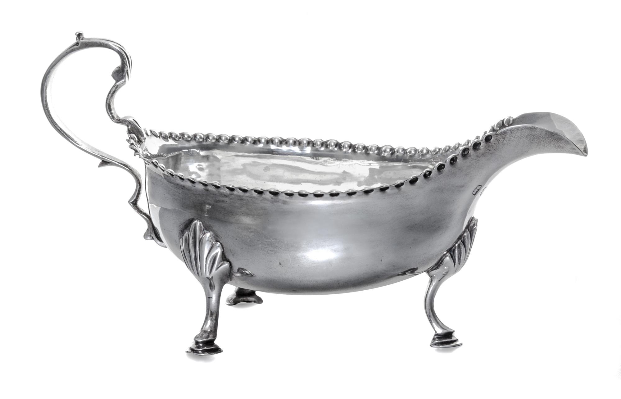 A George III Silver Sauce Boat, Hester Bateman, London, 1781, having a double scroll handle and a beaded edge, raised on foliate worked