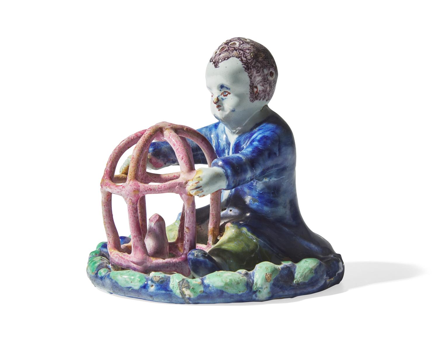 A small Dutch Delft figure of a boy holding birdcage with bird, 18th century