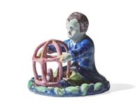 A small Dutch Delft figure of a boy holding birdcage with bird, 18th century