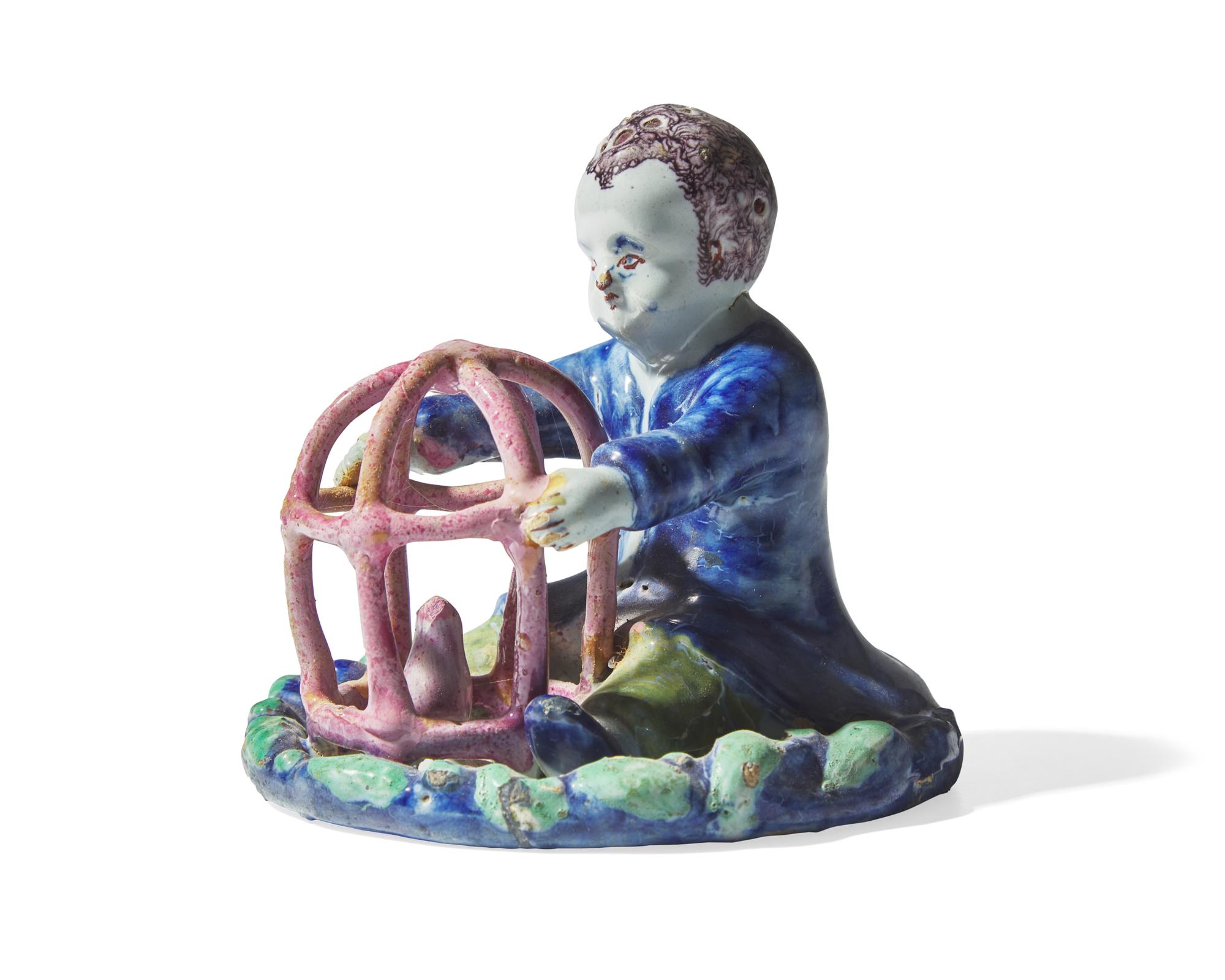 A small Dutch Delft figure of a boy holding birdcage with bird, 18th century