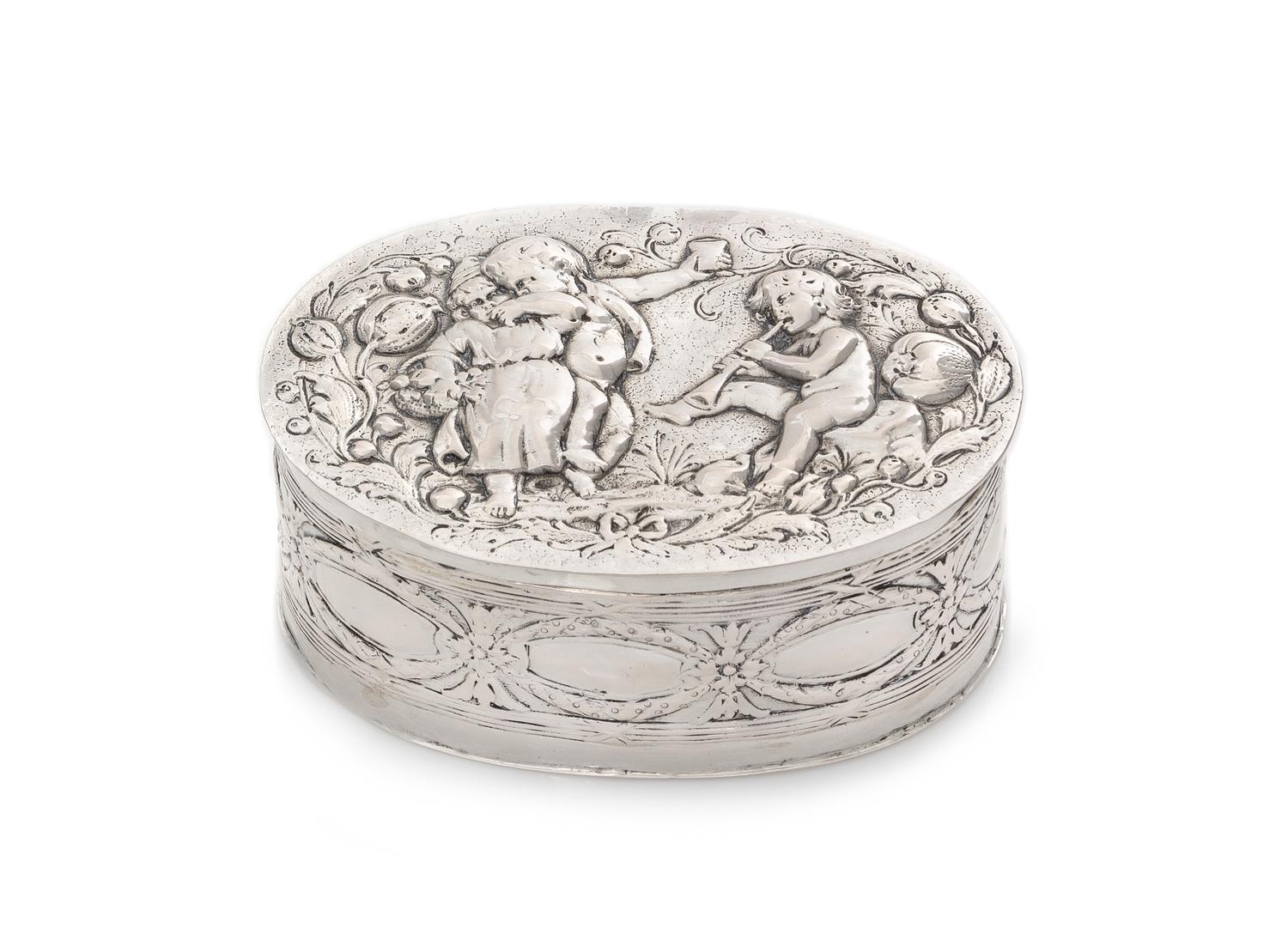 A German Silver Box, 19th/20th Century, of oval form, worked to show figures in relief.