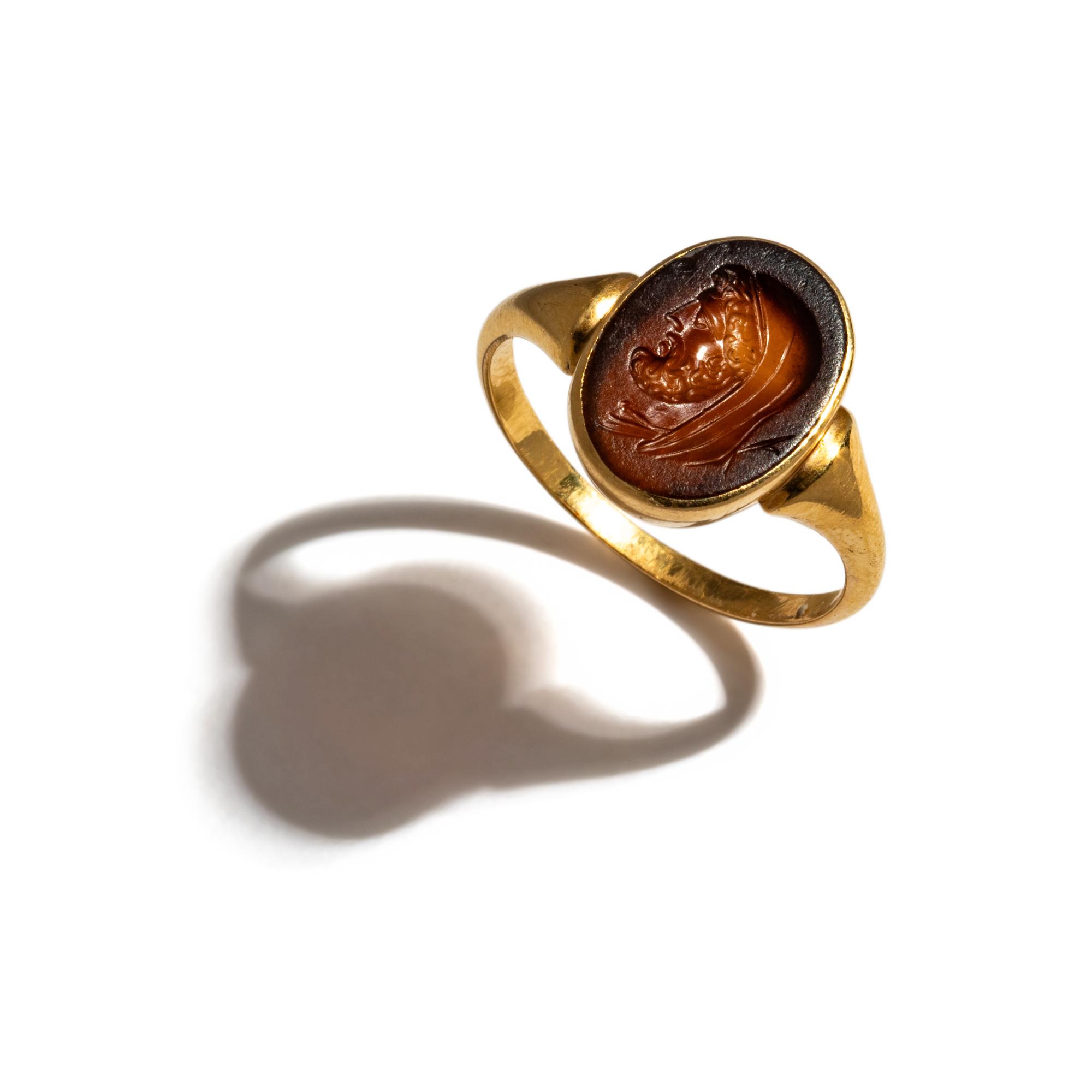 A Roman Carnelian Ring Stone with a Portrait Head of the God Cronus — Set in a gold ring