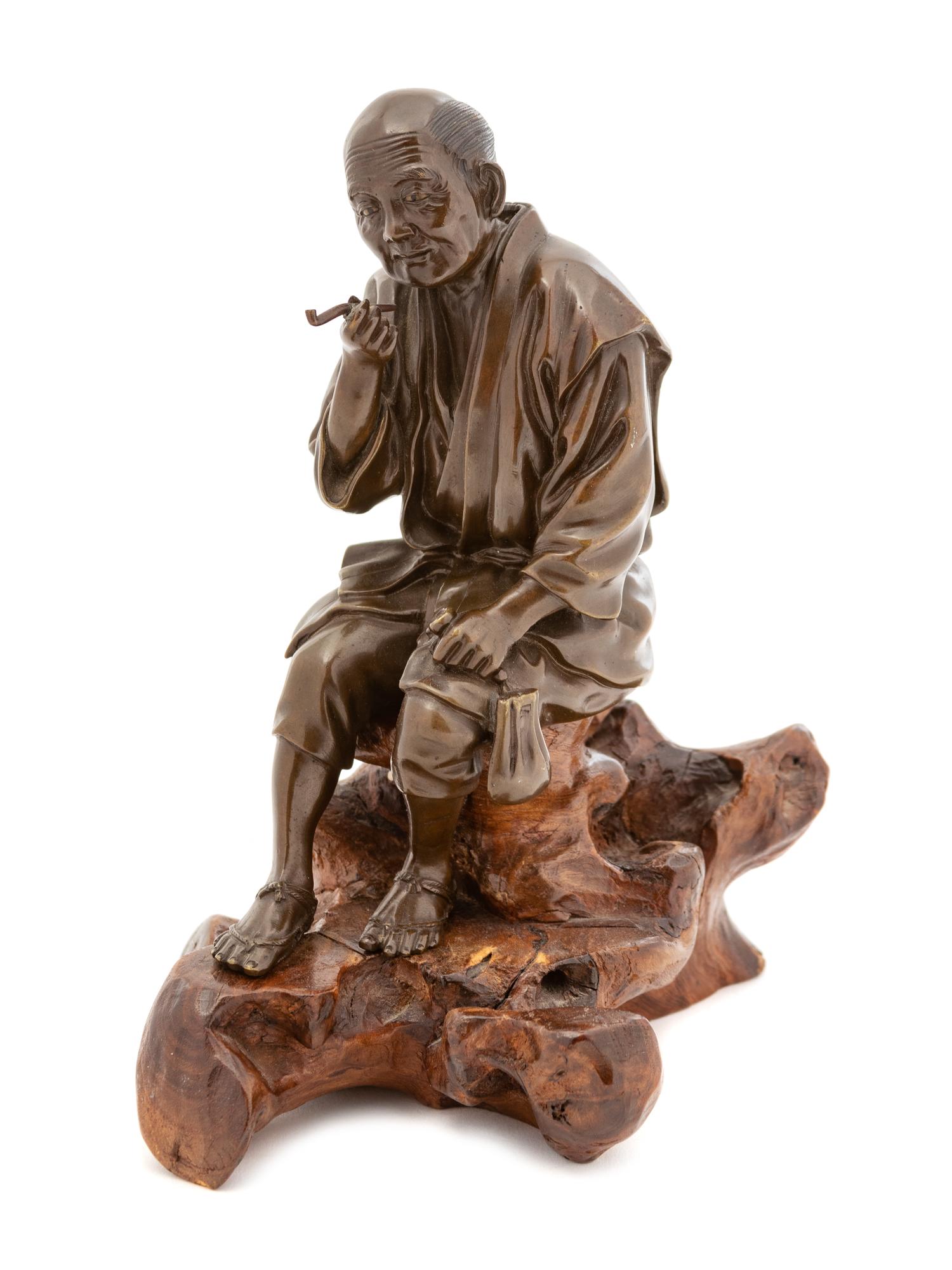 A Japanese Bronze of a Seated Man Smoking Pipe — EARLY 20TH CENTURY