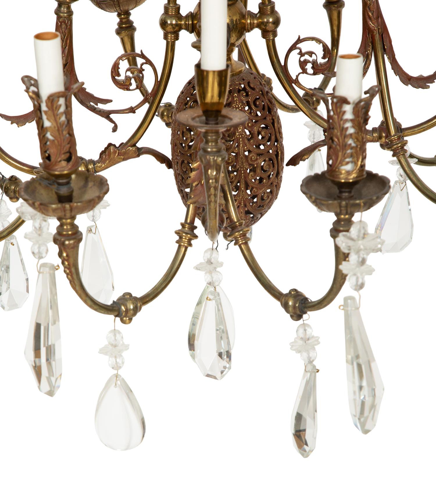 A Pierced Brass Eight-Light Chandelier with Crystal Drops