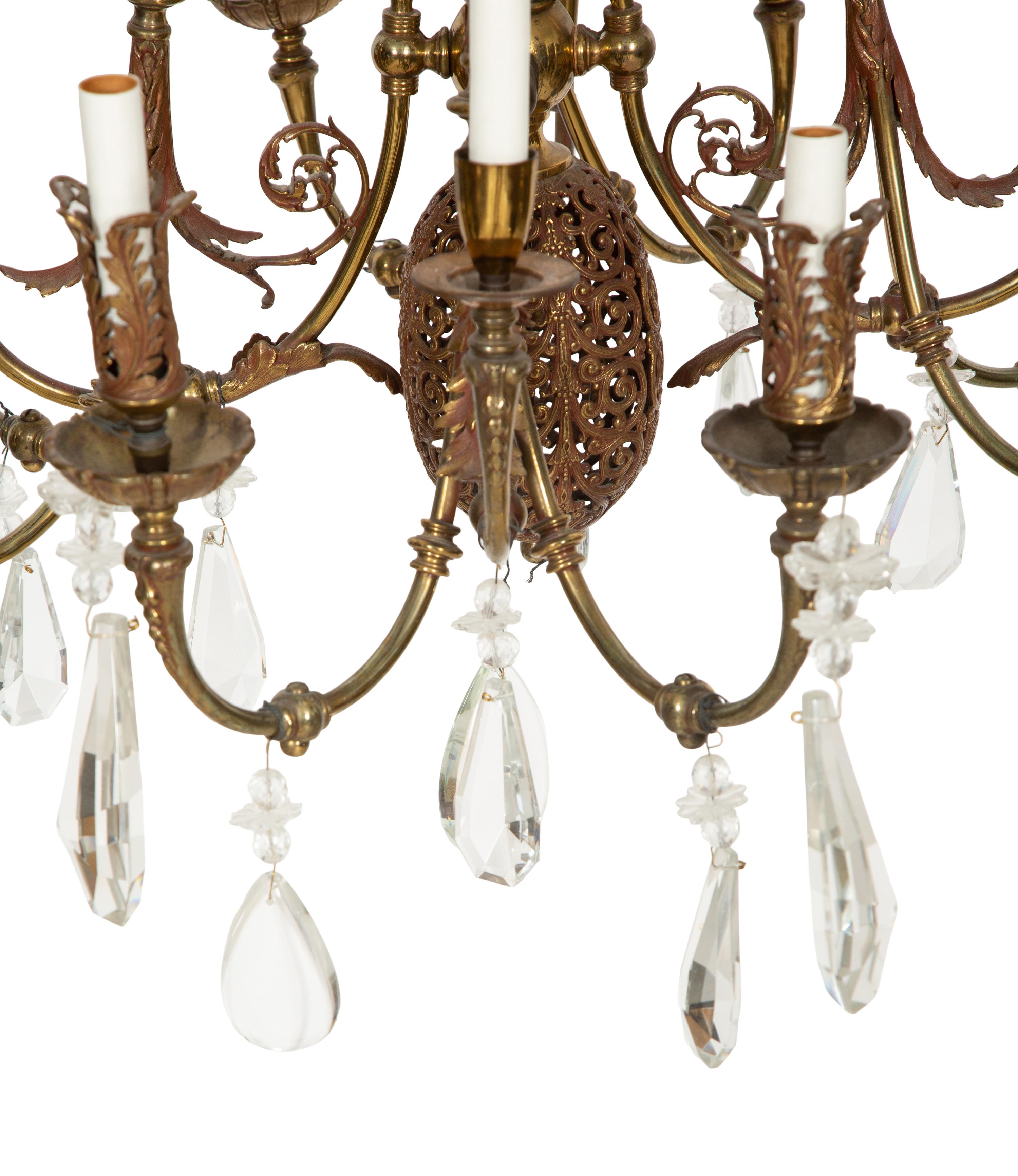 A Pierced Brass Eight-Light Chandelier with Crystal Drops