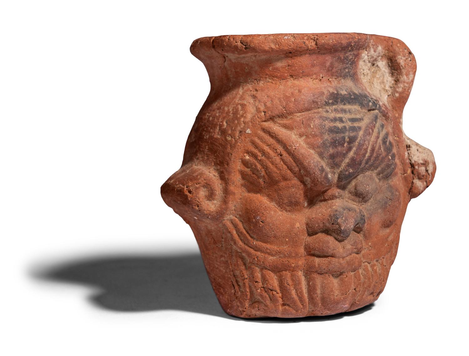 An Egyptian Terracotta Jar with the Head of Bes