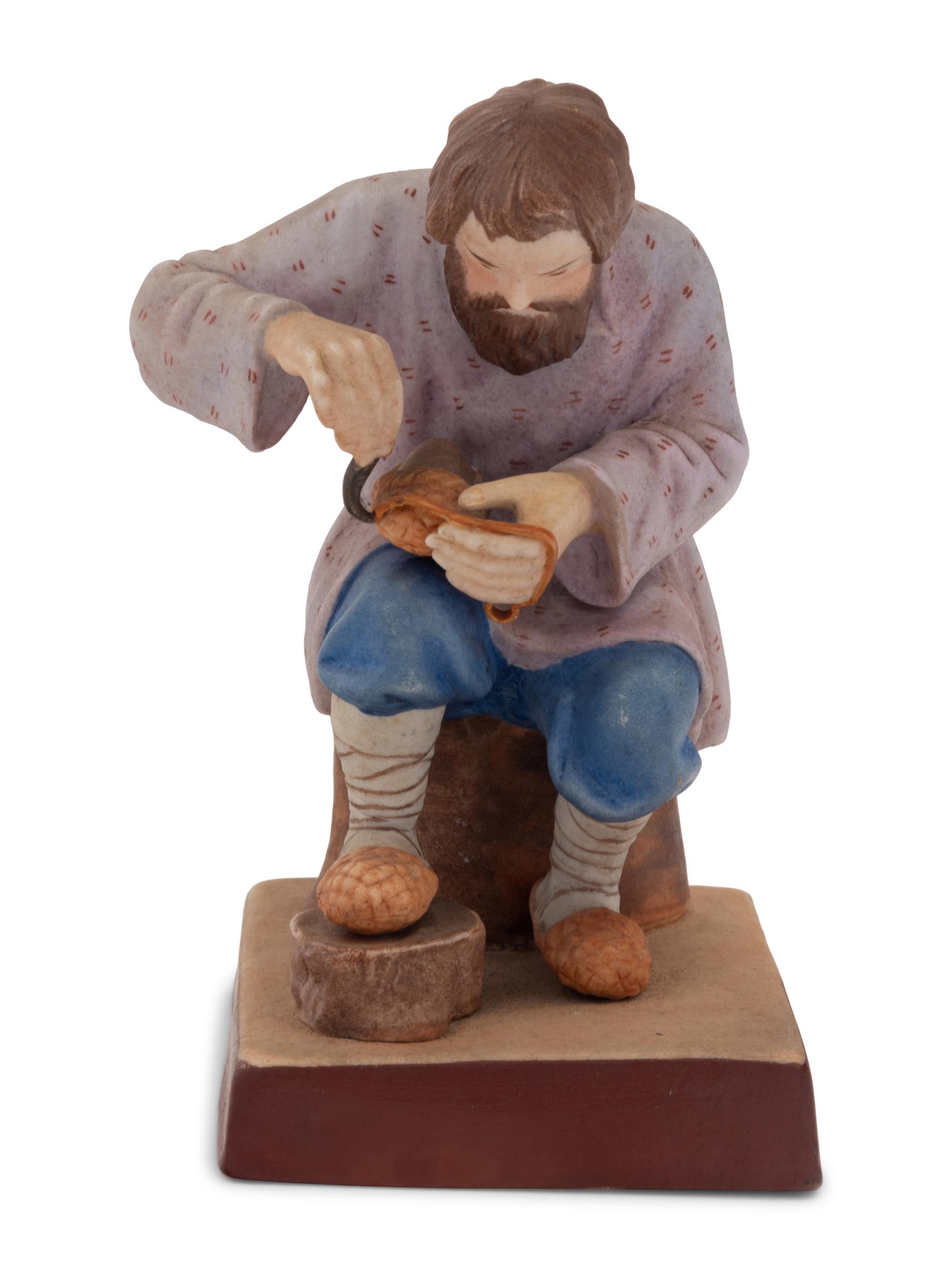 A Russian Porcelain Figure of a Bast Shoe Maker