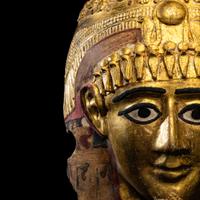 An Egyptian Gilt Cartonnage Mummy Mask of a Woman