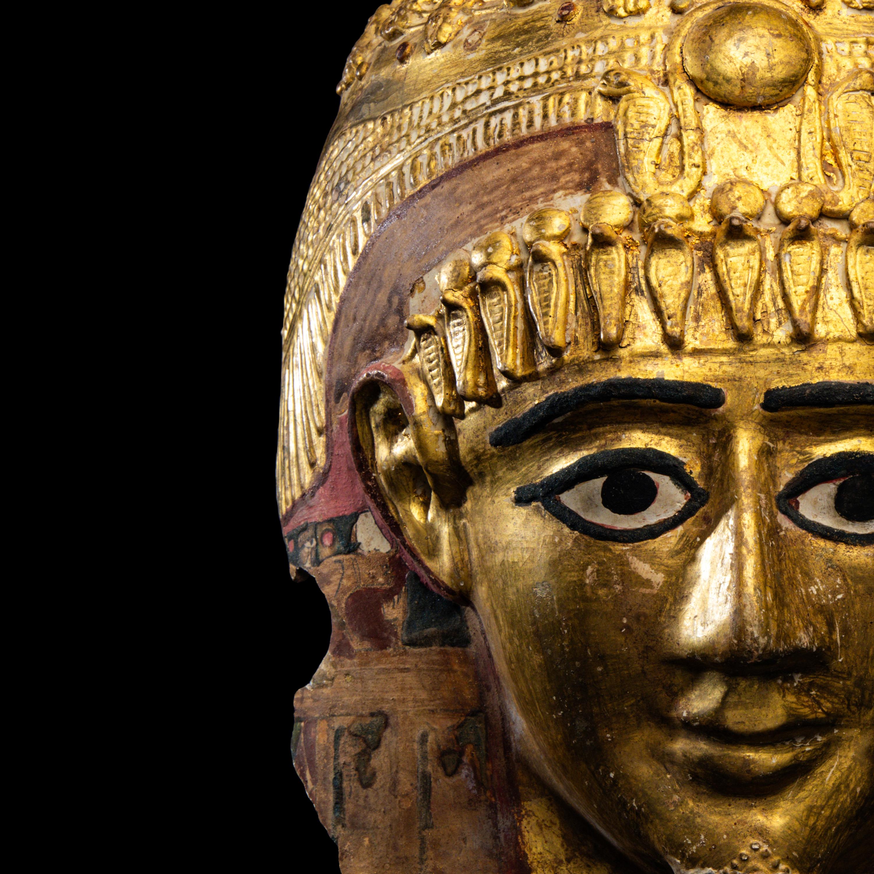 An Egyptian Gilt Cartonnage Mummy Mask of a Woman