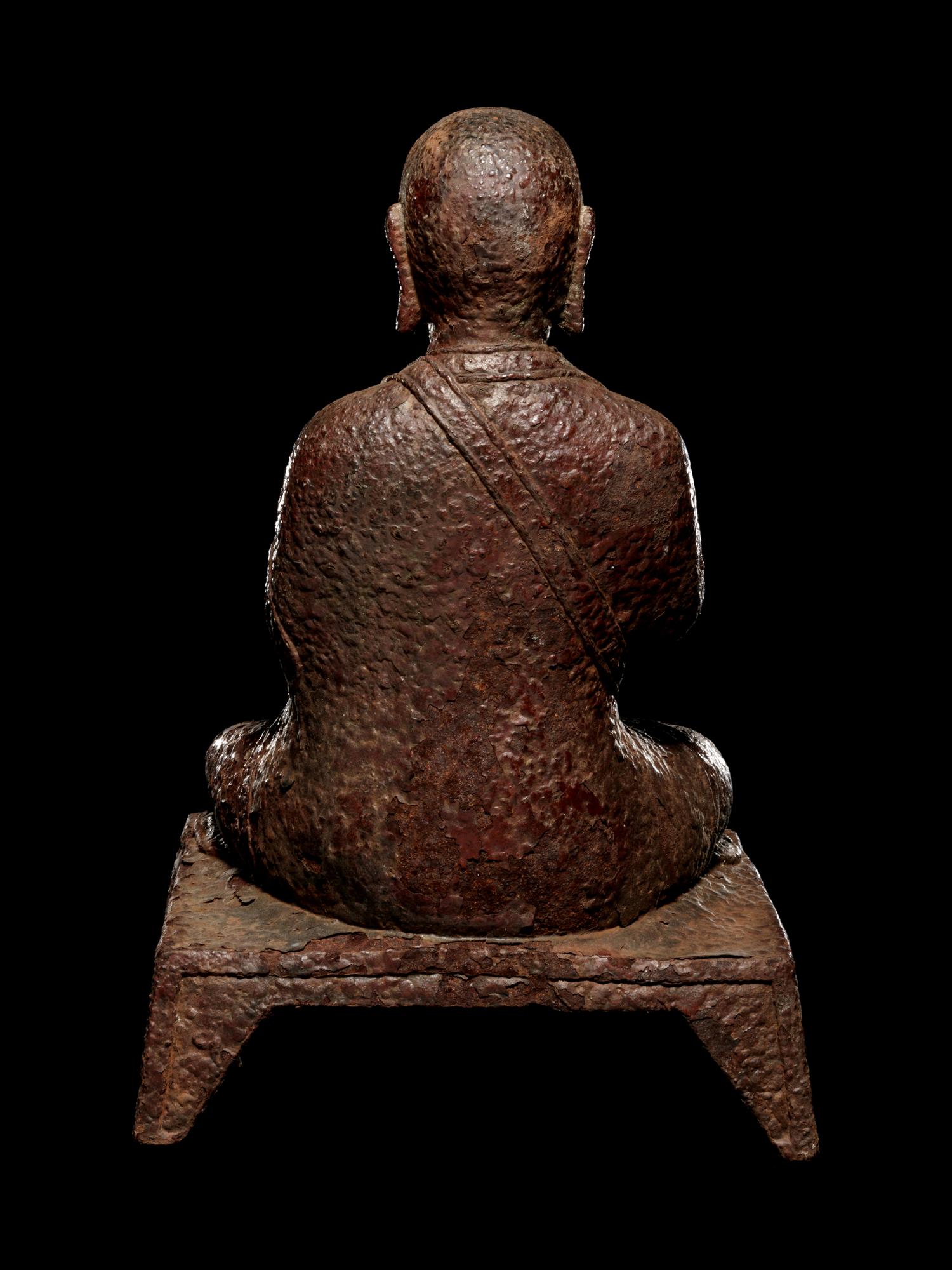 A Tibetan Cast Iron Figure of a Monk