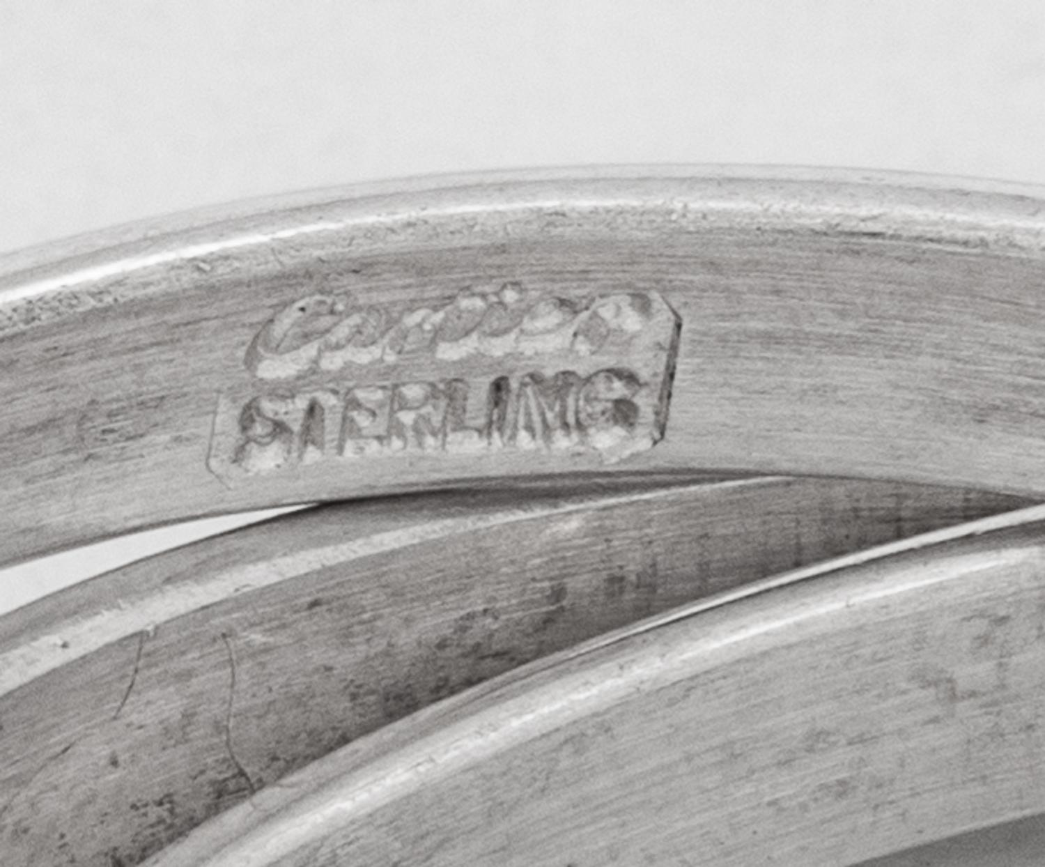Two Cased Sets of Four Cartier Trinity Silver Napkin Rings