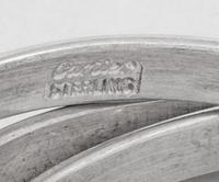Two Cased Sets of Four Cartier Trinity Silver Napkin Rings