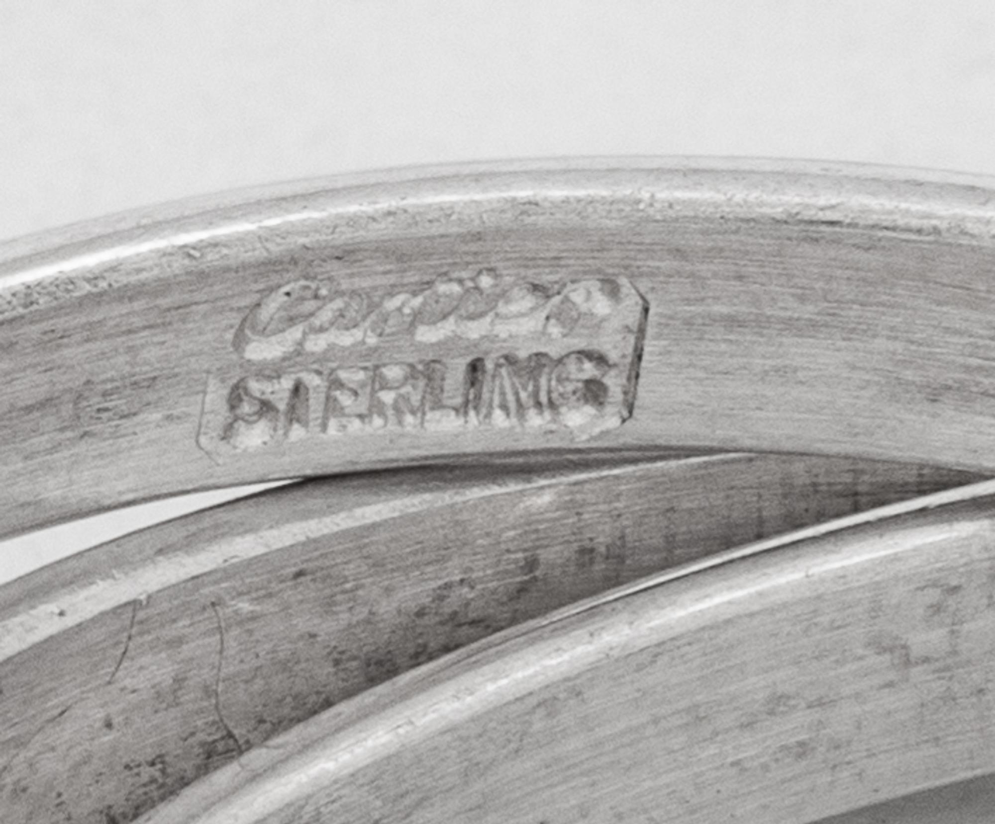 Two Cased Sets of Four Cartier Trinity Silver Napkin Rings