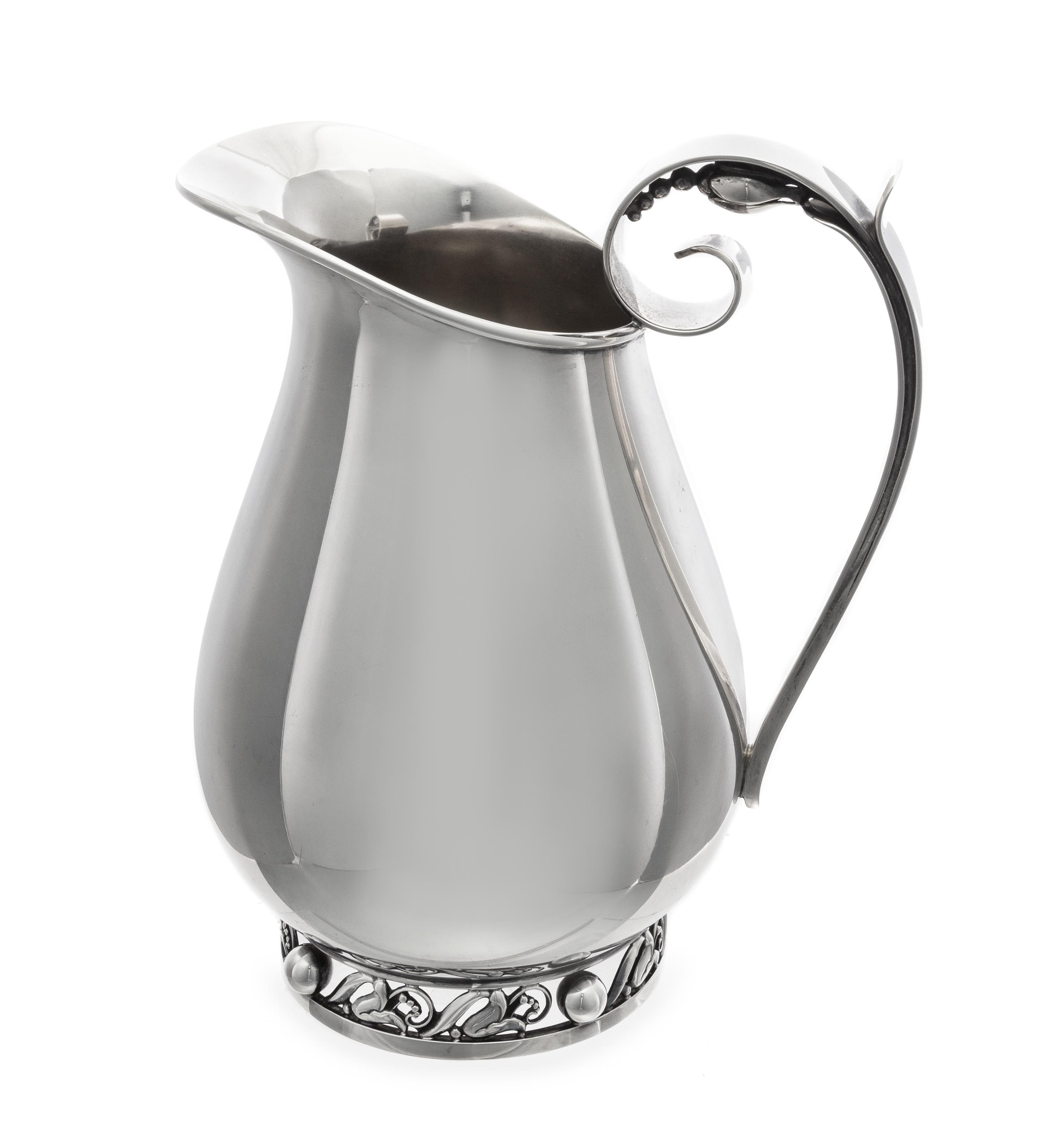 An American Silver Water Pitcher, Alphonse LaPaglia for International Silver Co., Meriden, CT, Mid-20th Century, the scrolled handle wi