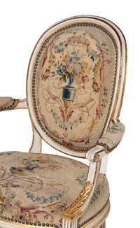 A Set of Four Louis XVI Crème-Painted and Parcel Gilt Fauteuils