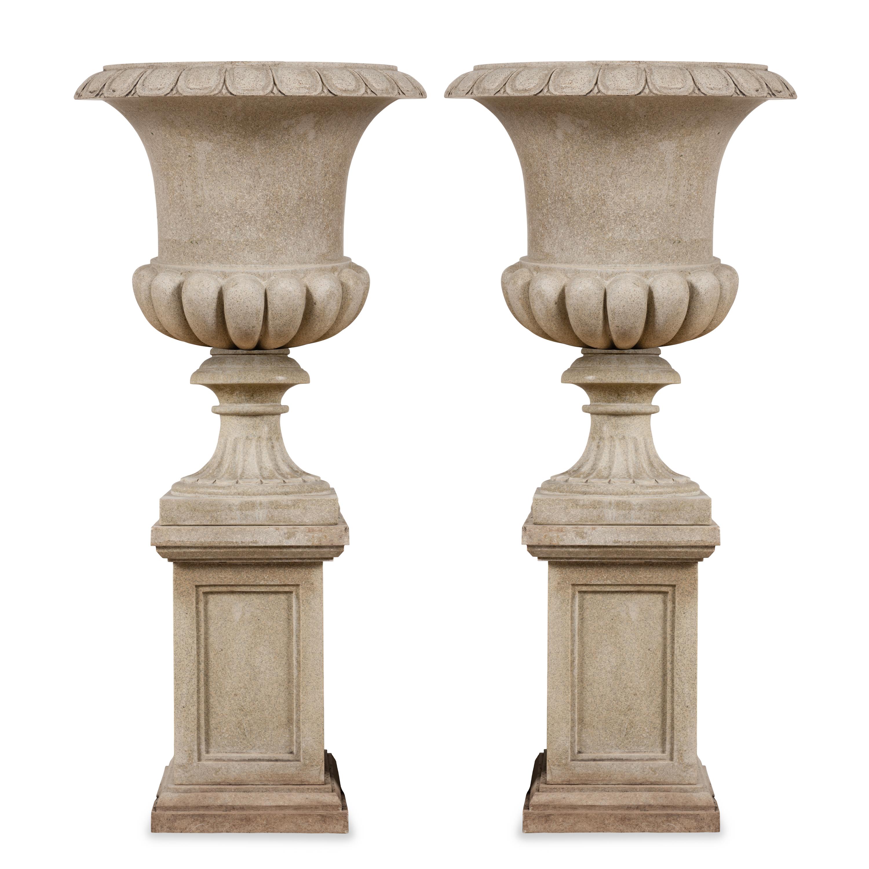 A Pair of Carved Granite Urns and Plinths