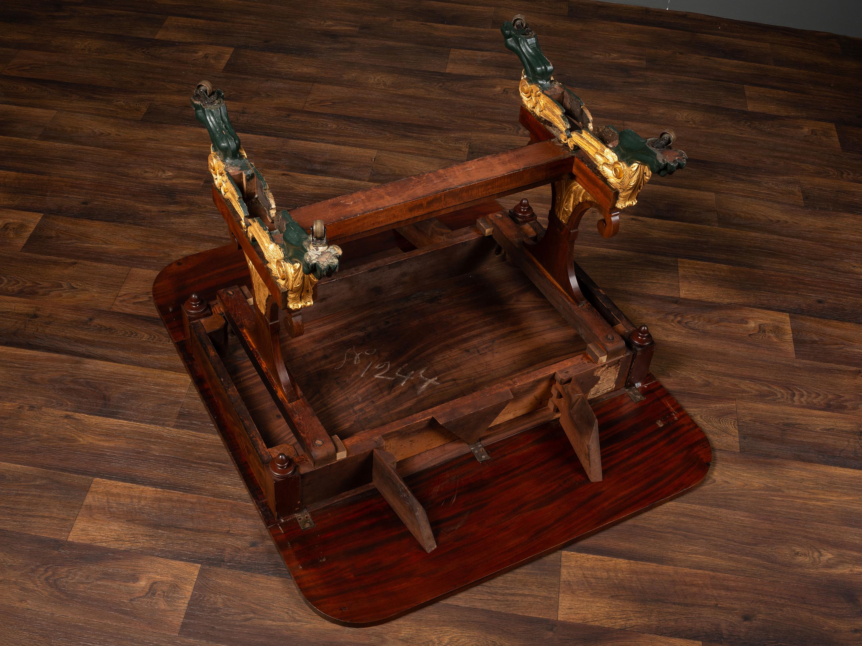 A Classical Parcel Gilt and Ebonized, Figured Mahogany Paw-Foot Drop-Leaf Table