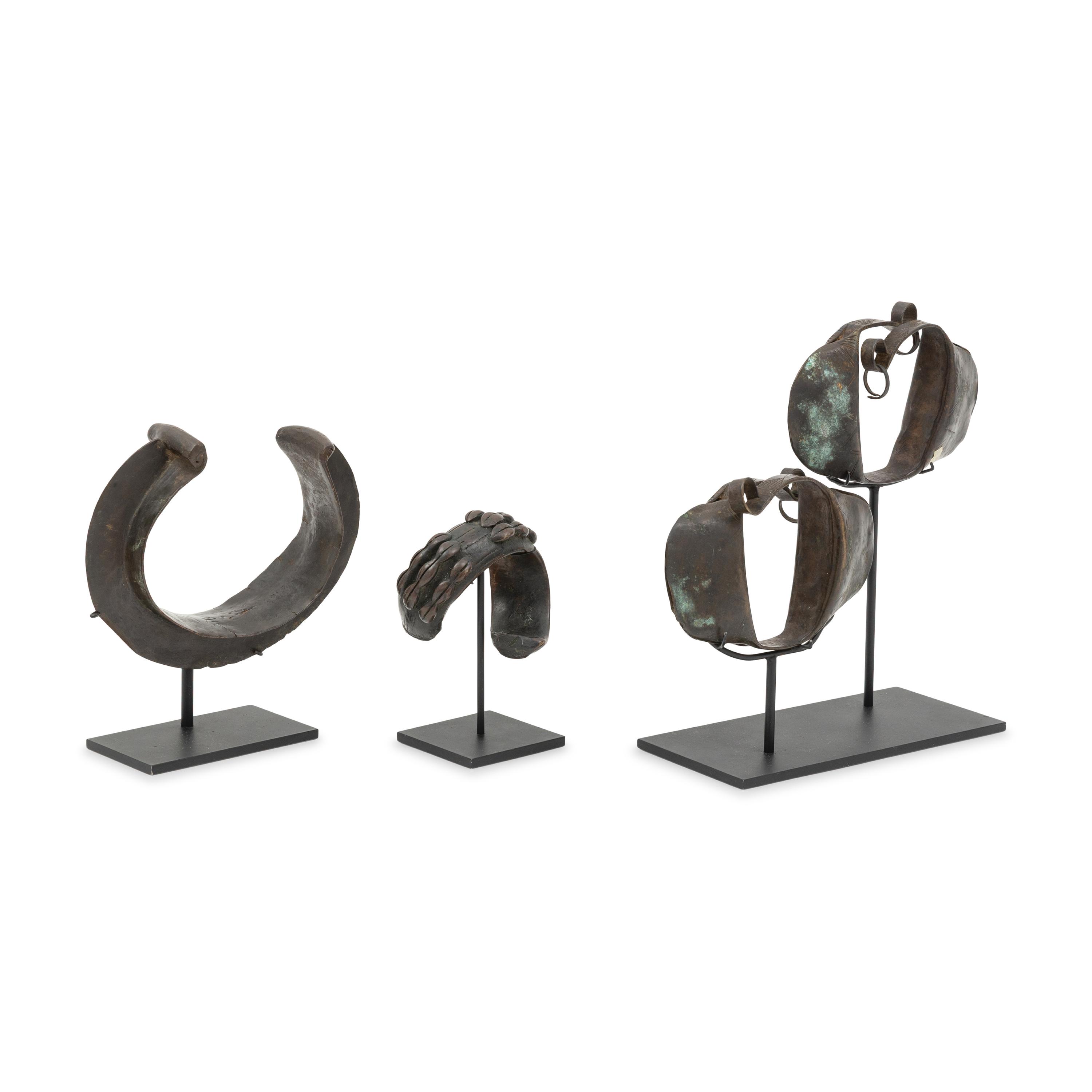 Four African Bronze Adornments on Fitted Stands