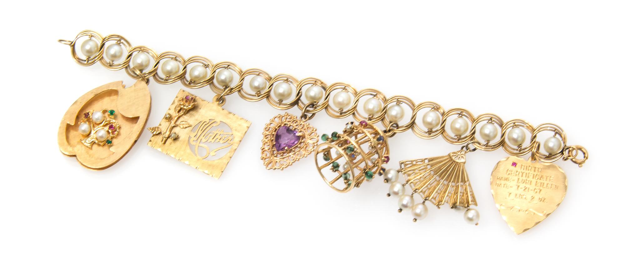 A Yellow Gold and Cultured Pearl Charm Bracelet with Six Attached Charms, 25.30 dwts.
