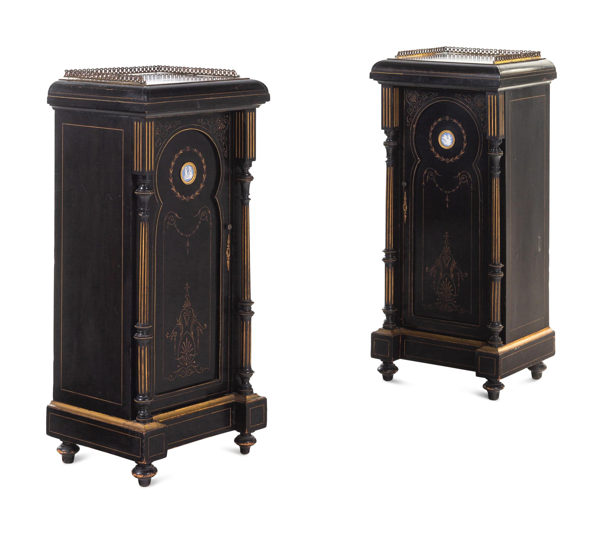 A Pair of English Aesthetic Jasperware Medallion-Mounted Ebonized and Parcel-Gilt Pedestal Cabinets
