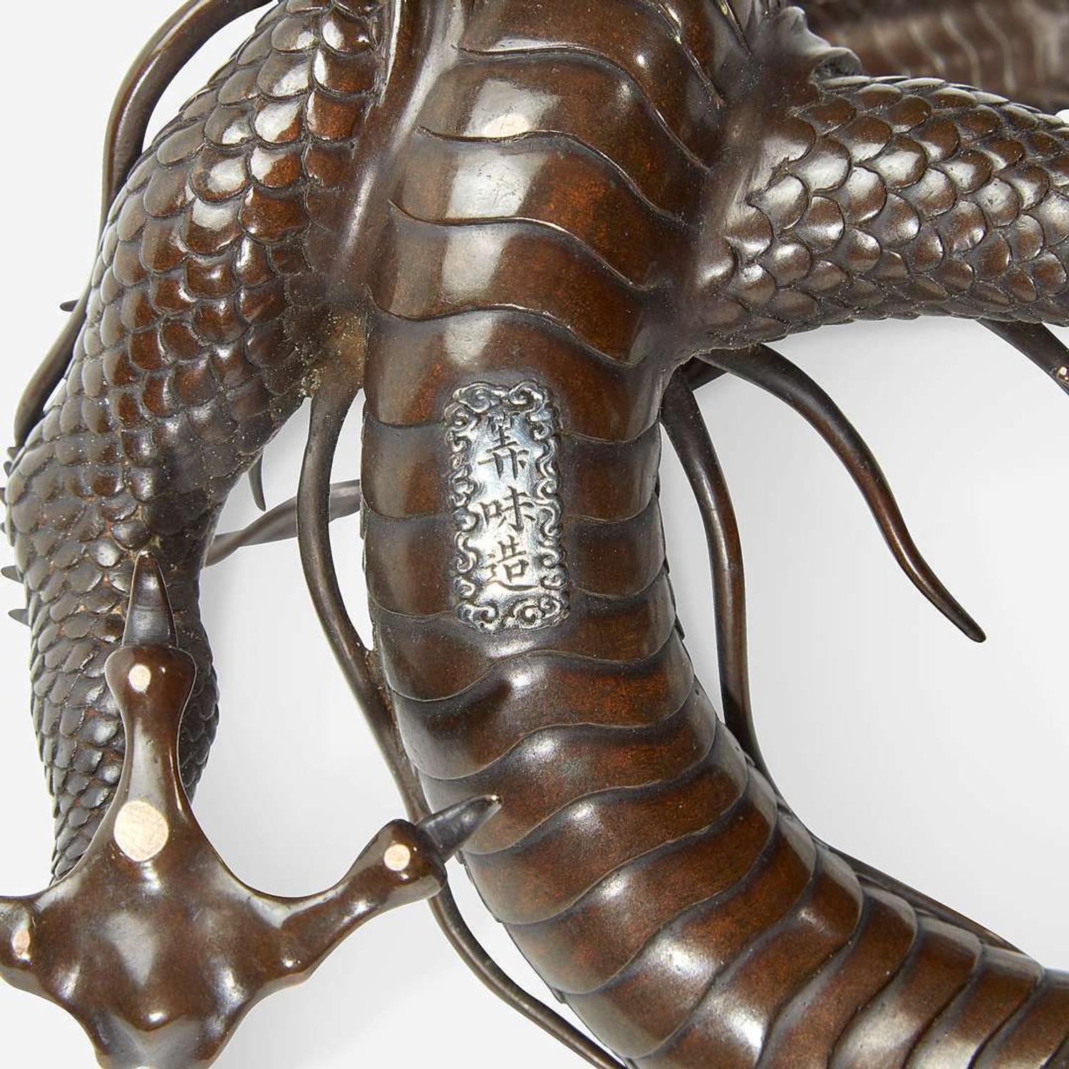 A Japanese patinated bronze dragon and rock crystal sphere Meiji period
