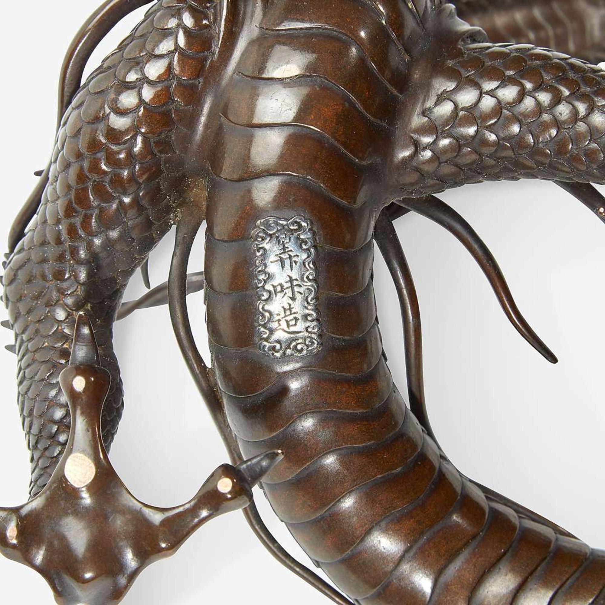 A Japanese patinated bronze dragon and rock crystal sphere Meiji period