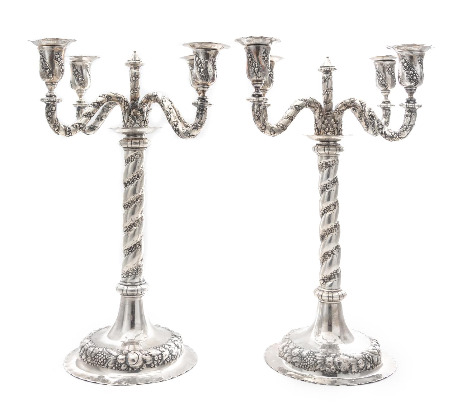 A Pair of German Silver Four-Light Candelabra, Early 20th Century, each central stem issuing four S-scroll candle arms worked to show t