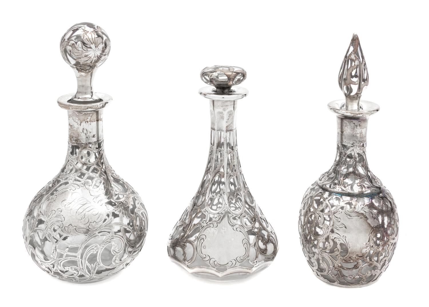 A Group of Three Silver Overlay Glass Bottles Height of tallest 7 1/2 inches.