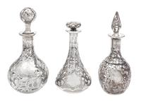 A Group of Three Silver Overlay Glass Bottles Height of tallest 7 1/2 inches.