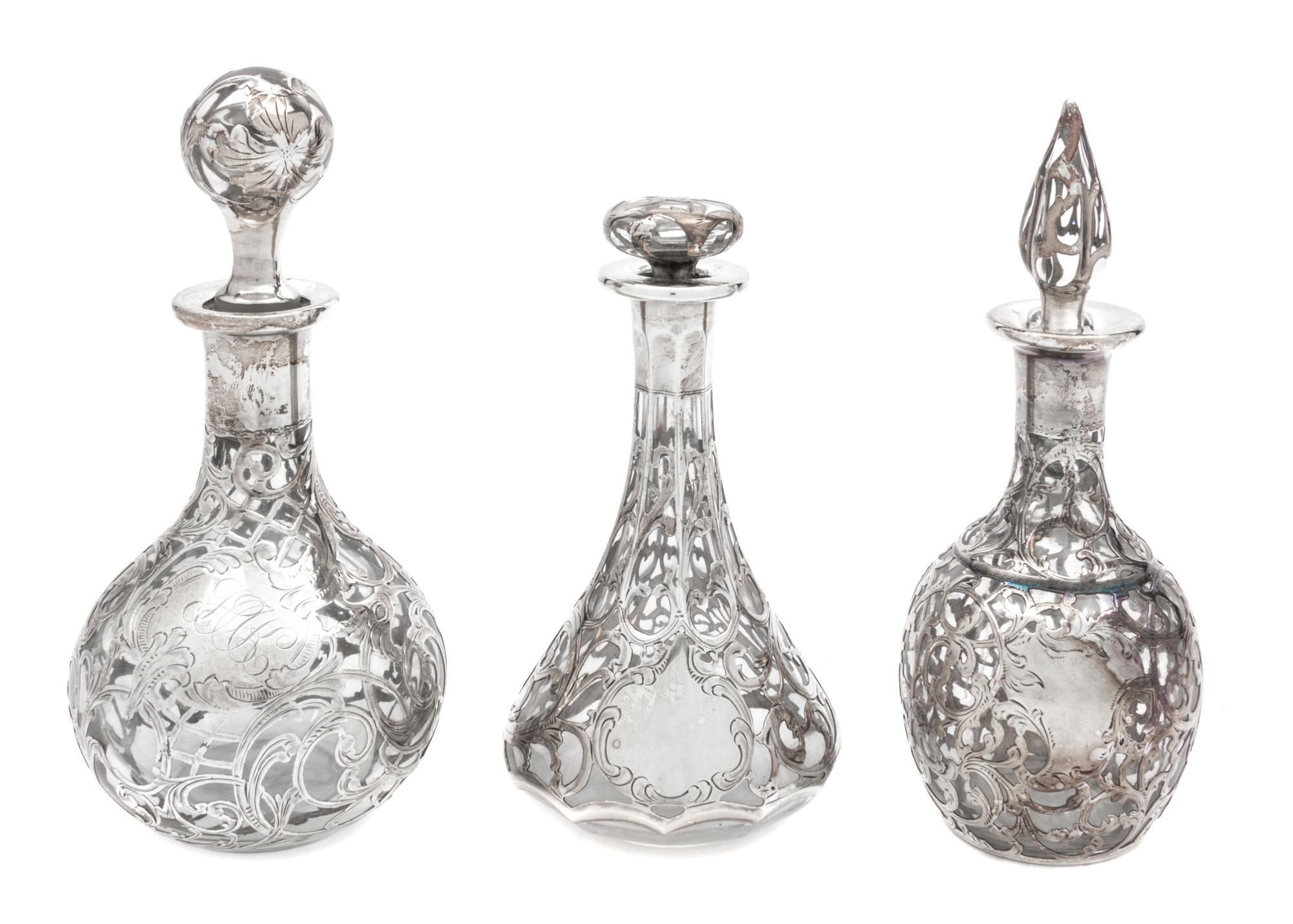 A Group of Three Silver Overlay Glass Bottles Height of tallest 7 1/2 inches.